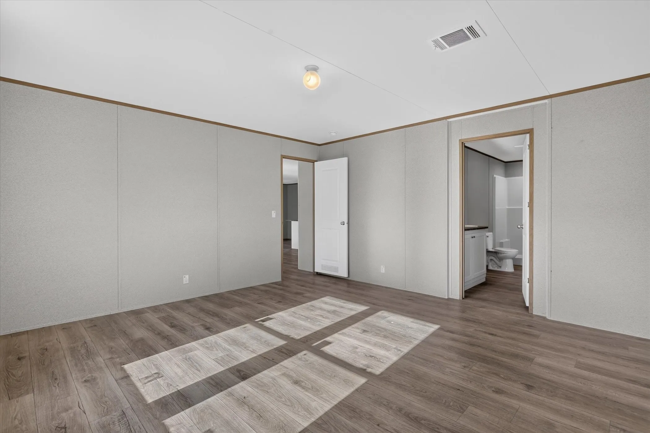 Wood-finish flooring, recessed lighting, and panel walls with trim details