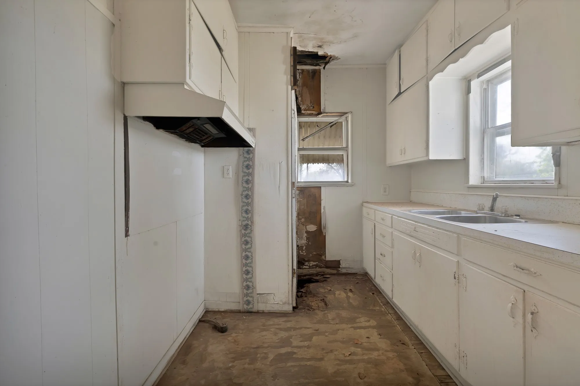 Kitchen with light countertops, white cabinetry, and exhaust hood
