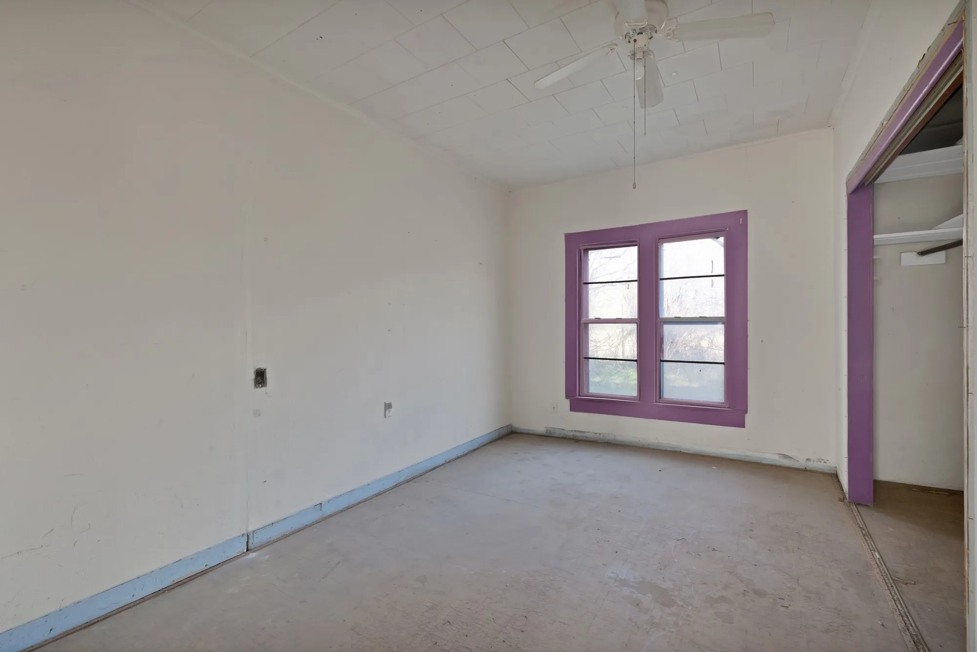 Unfurnished bedroom with a closet, ceiling fan, and concrete floors