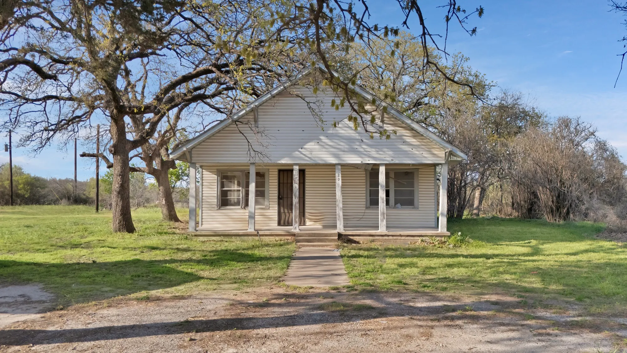 Bungalow featuring covered porch and a front lawn