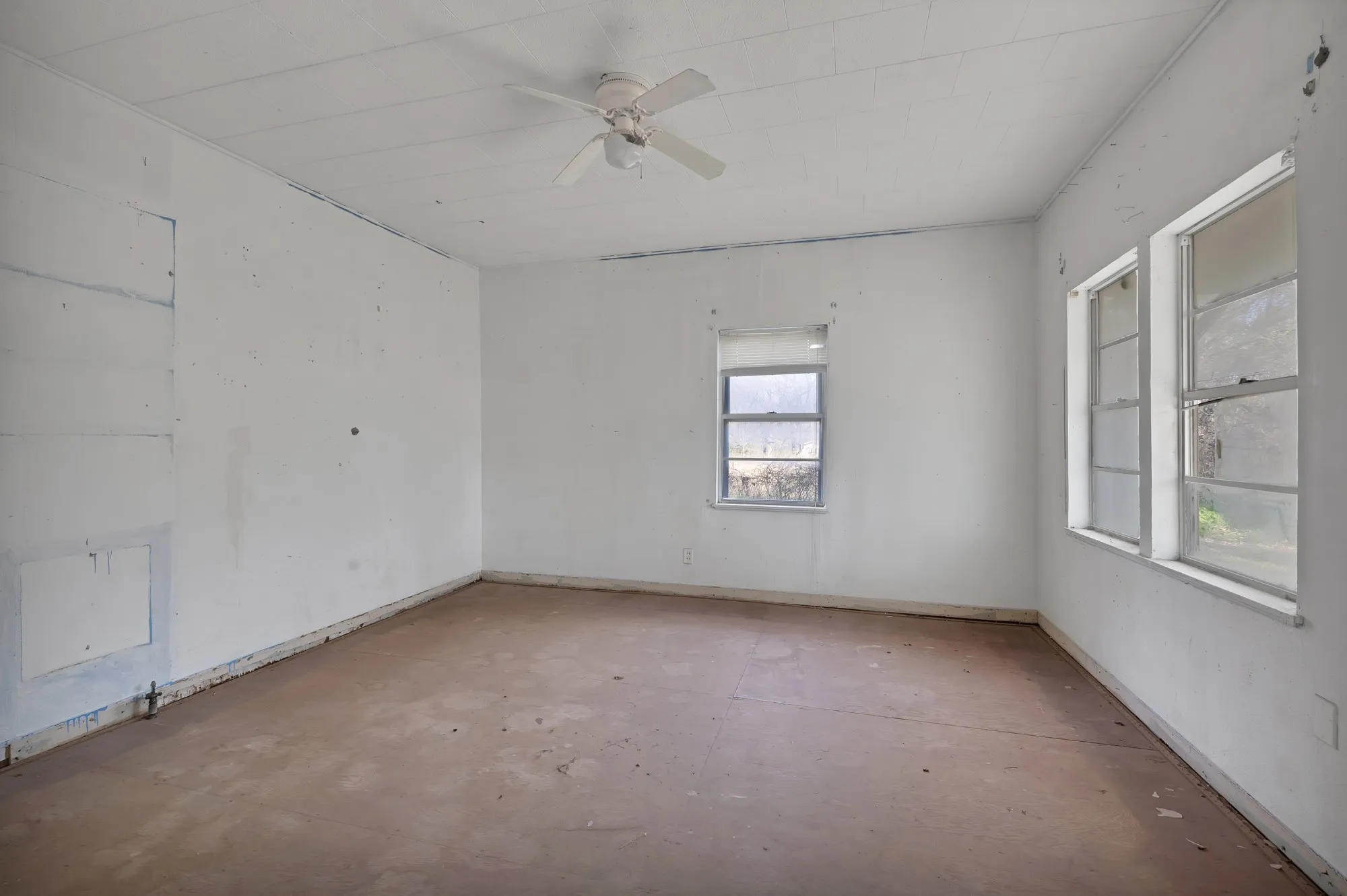 Empty room with a ceiling fan and unfinished concrete flooring