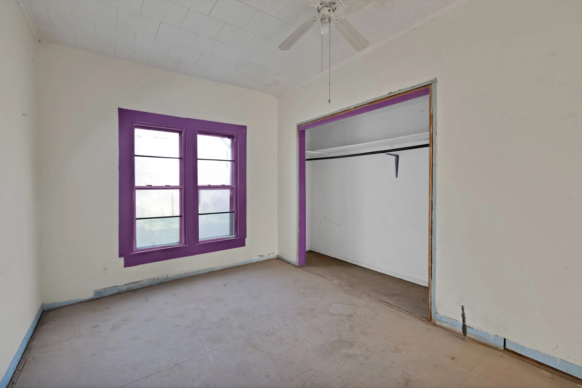 Unfurnished bedroom with ceiling fan and a closet