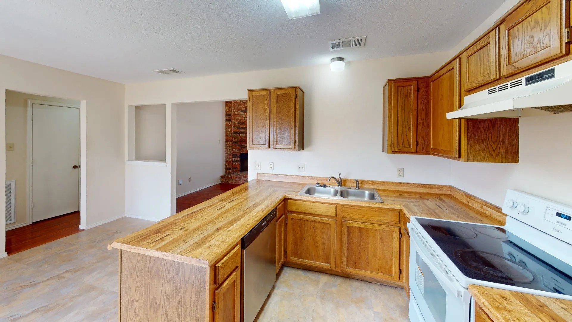 Kitchen featuring wood-finish cabinetry, stainless steel dishwasher, white range, dual basin sink, and wood-finish countertops