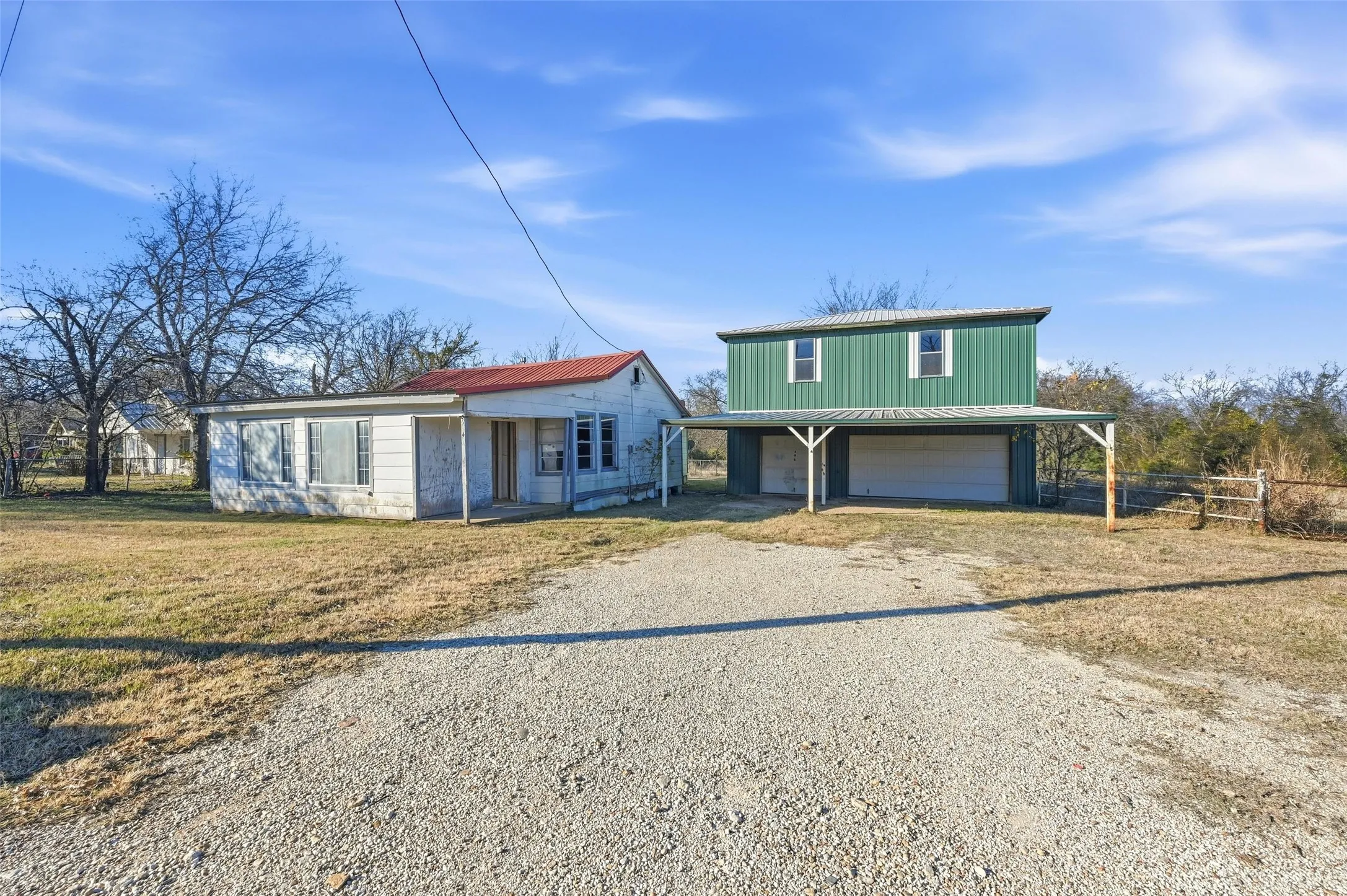 View of front facade with driveway, an attached garage, and a patio