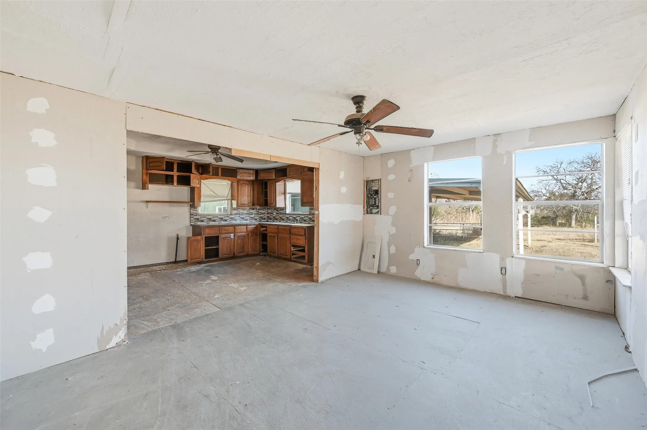 Unfurnished living room featuring plenty of natural light and a ceiling fan