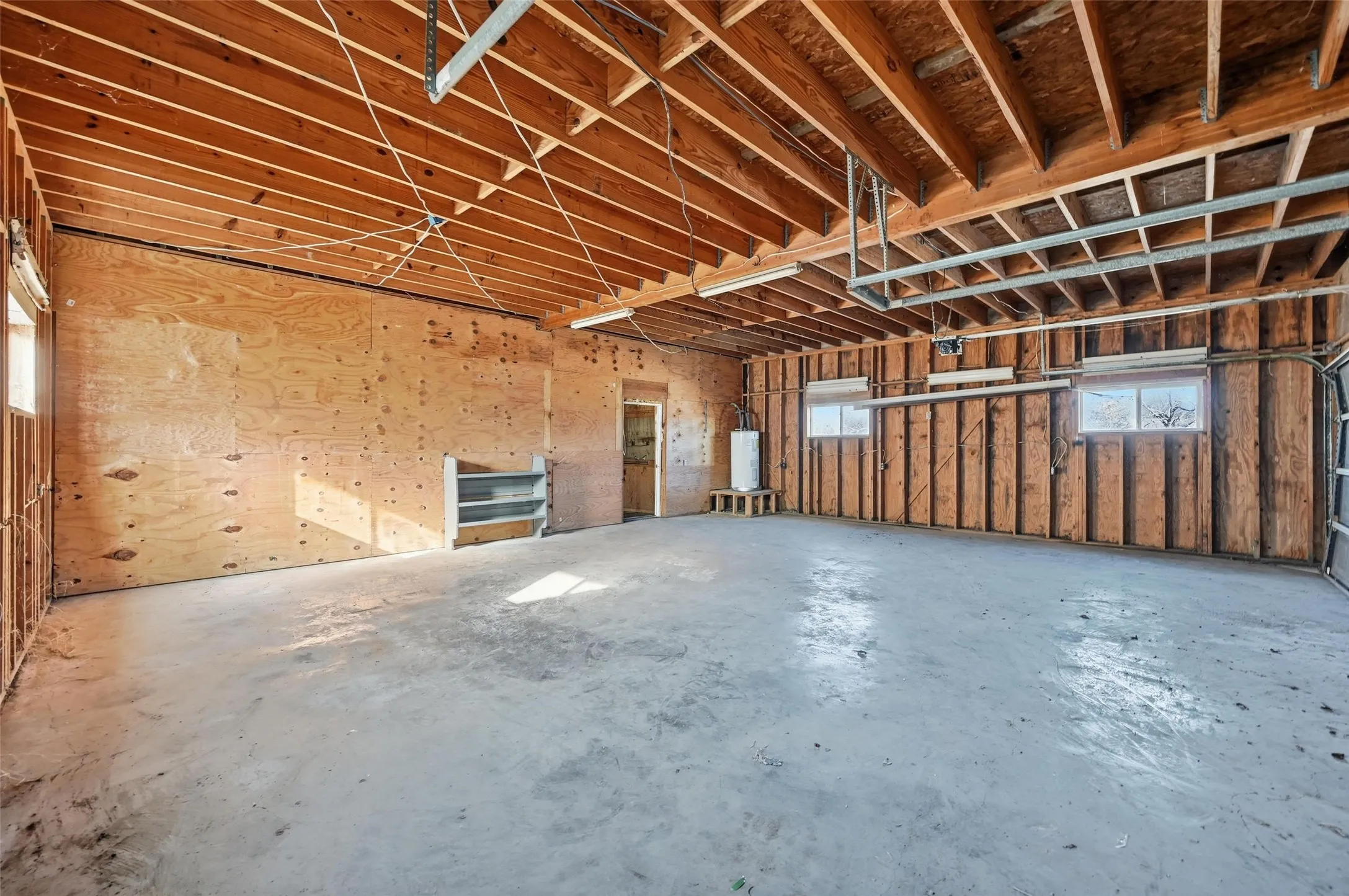 Miscellaneous room featuring a garage and unfinished concrete floors