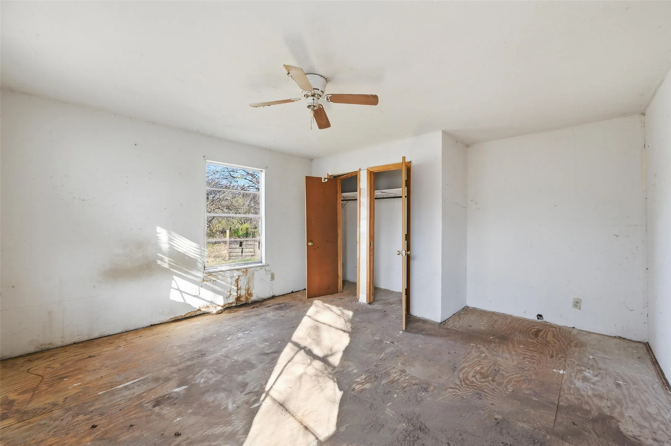 Unfurnished bedroom with a ceiling fan and multiple closets