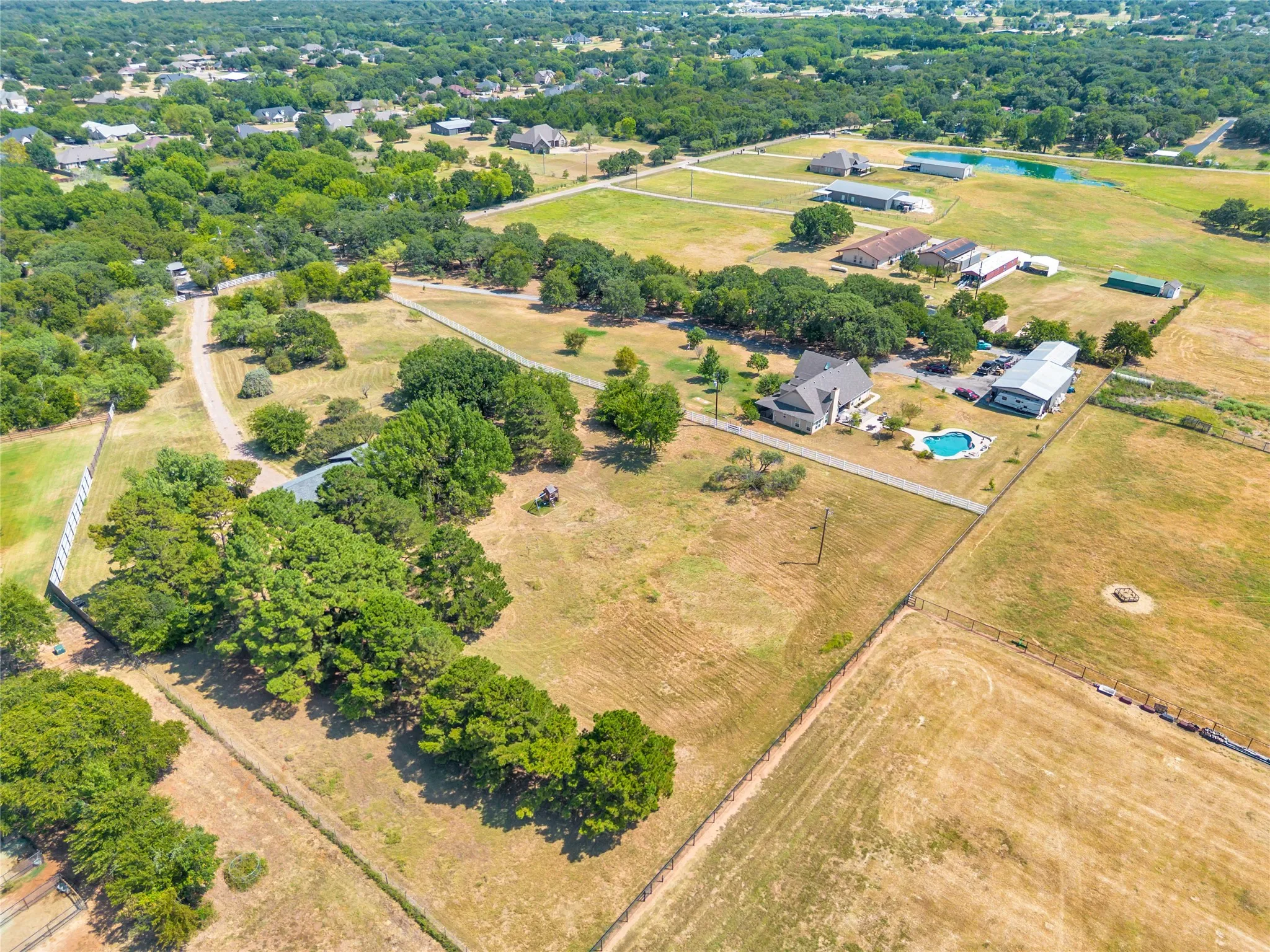 Expansive property featuring a private dwelling, detached auxiliary structure, and a swimming pool