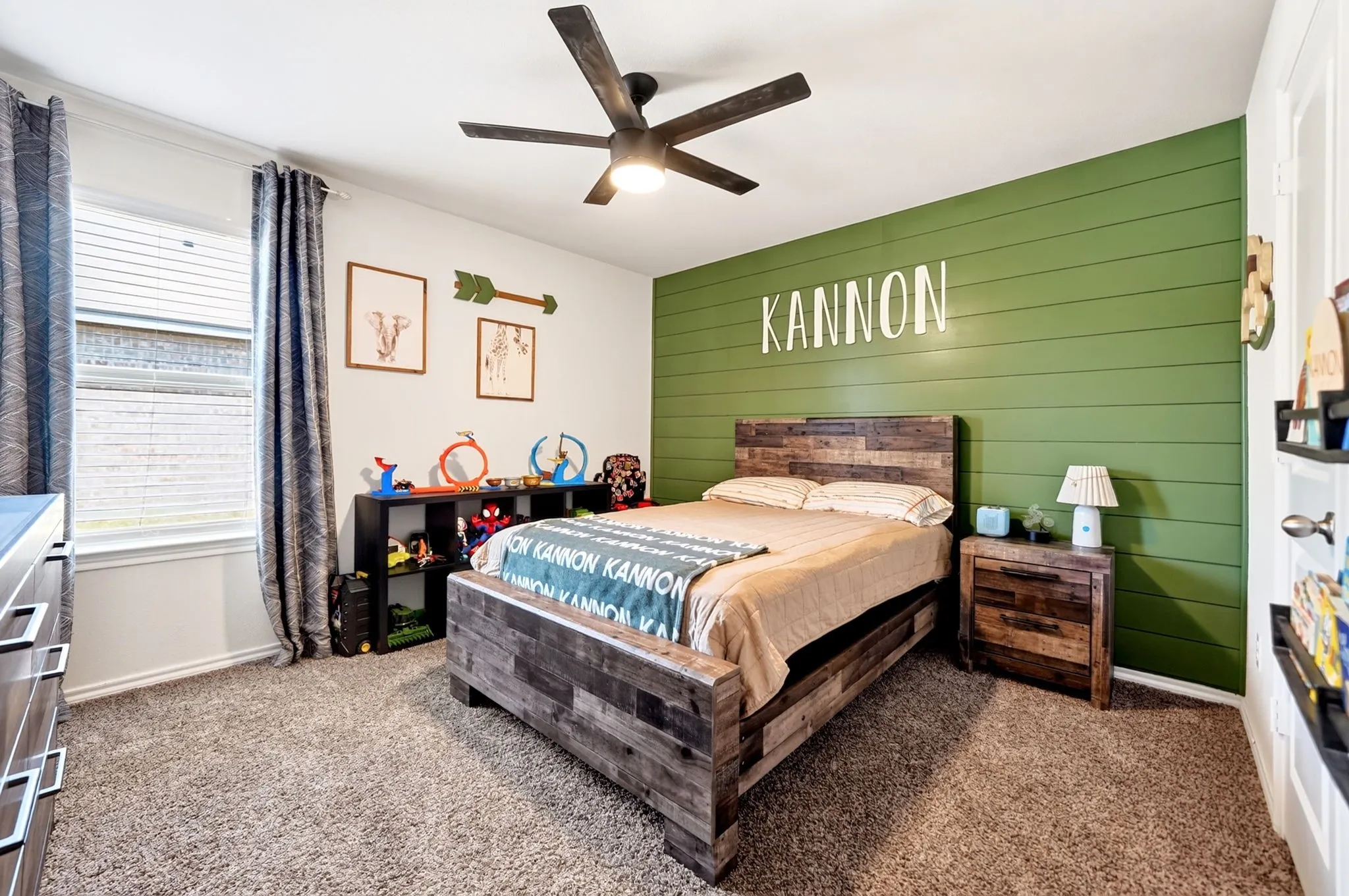 Carpeted flooring, window with blinds, ceiling fan with integrated lighting, built-in shelving, and a shiplap accent wall
