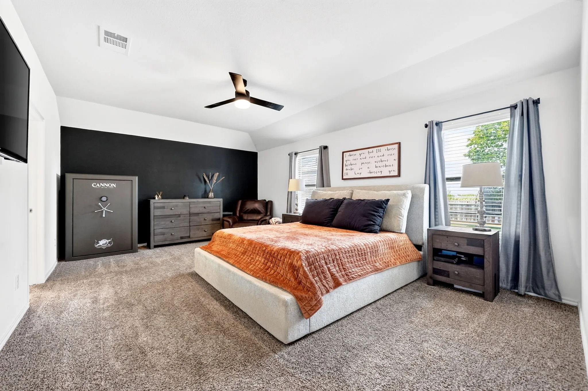 Vaulted ceiling with a contemporary ceiling fan, dual windows, and plush carpet flooring