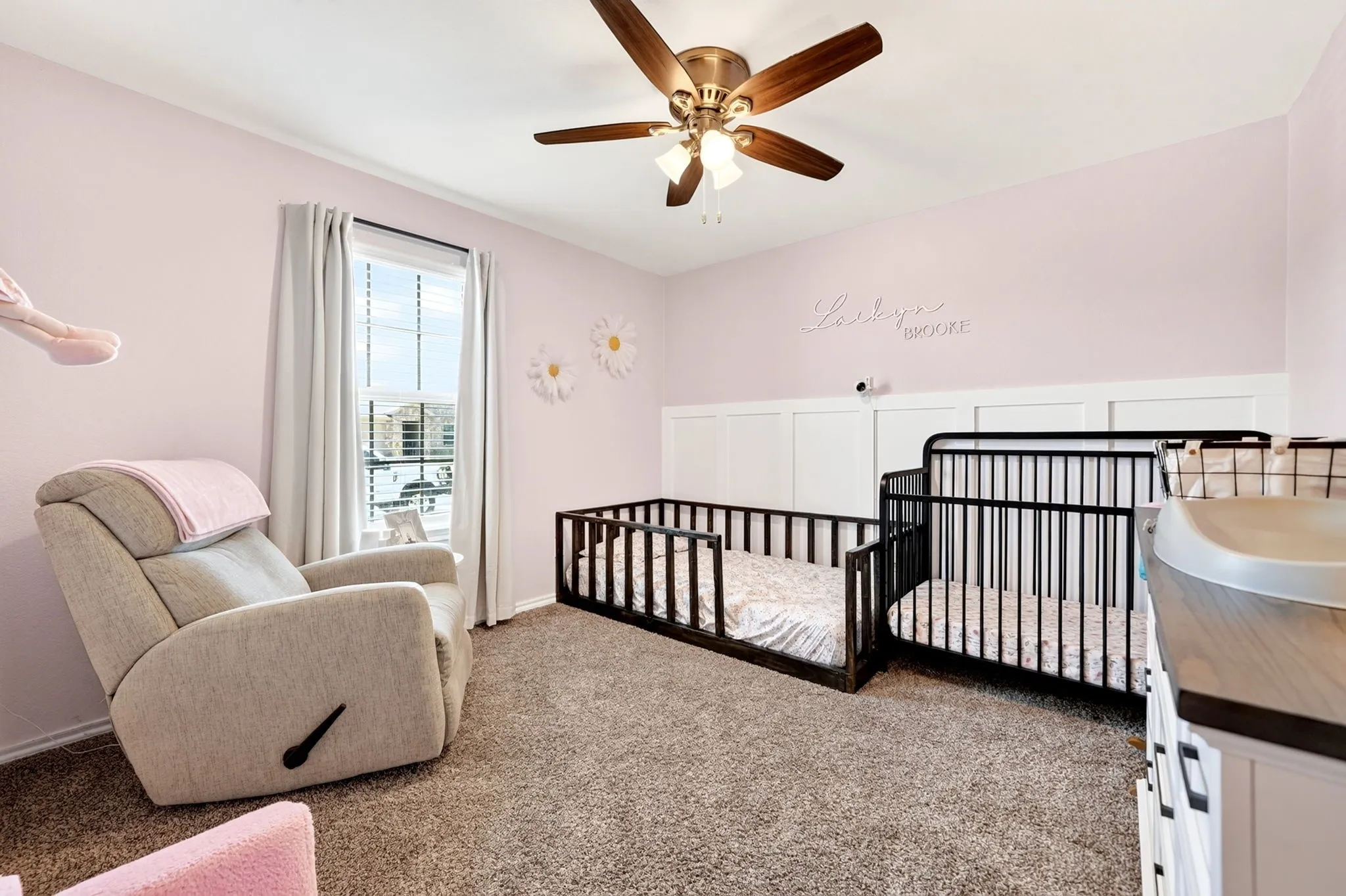 Neutral wall color with wainscoting detail, ceiling fan with light fixture, carpeted flooring, and a single window with blinds