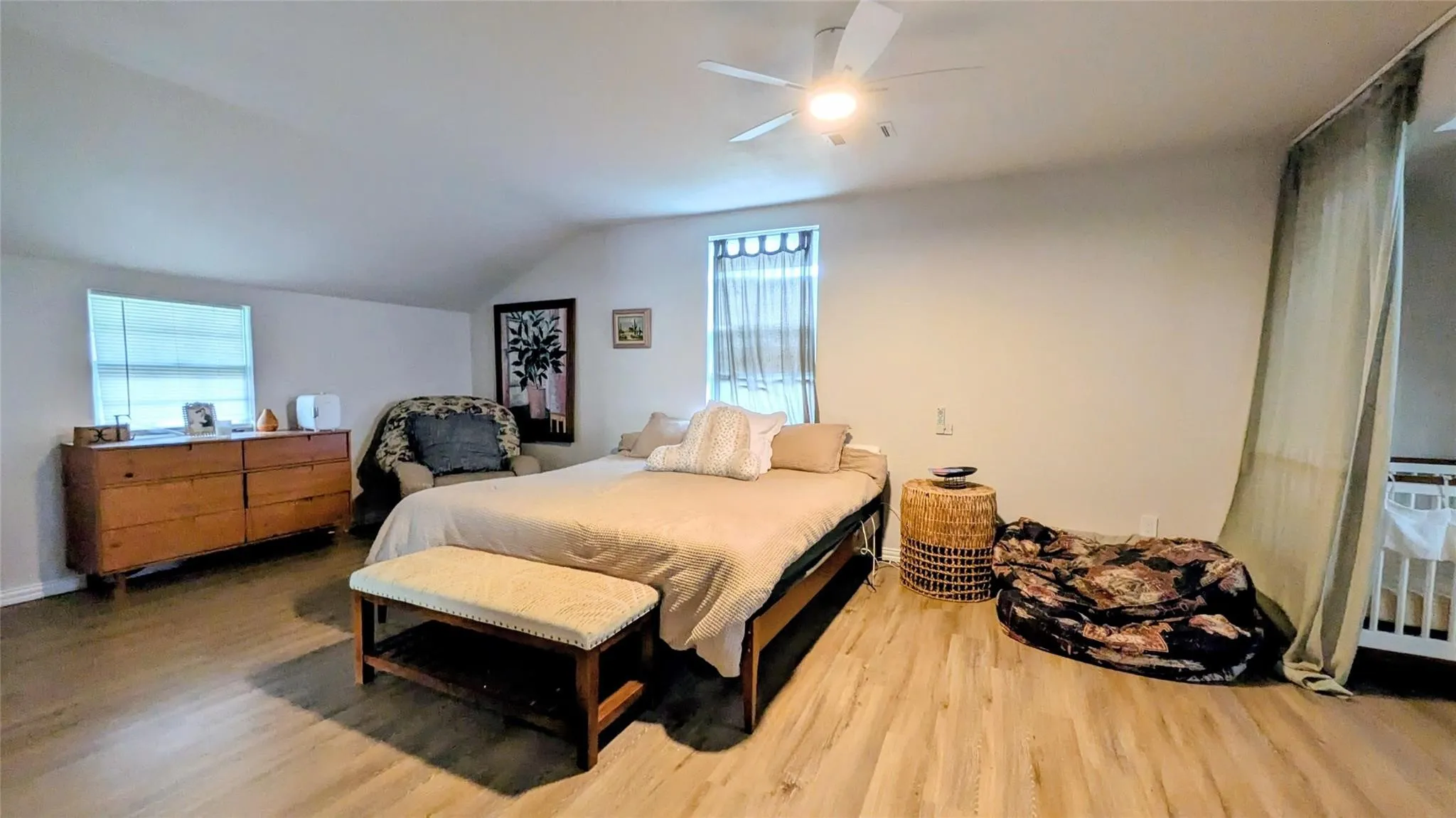 Ceiling fan, two windows with blinds, and laminate finish flooring