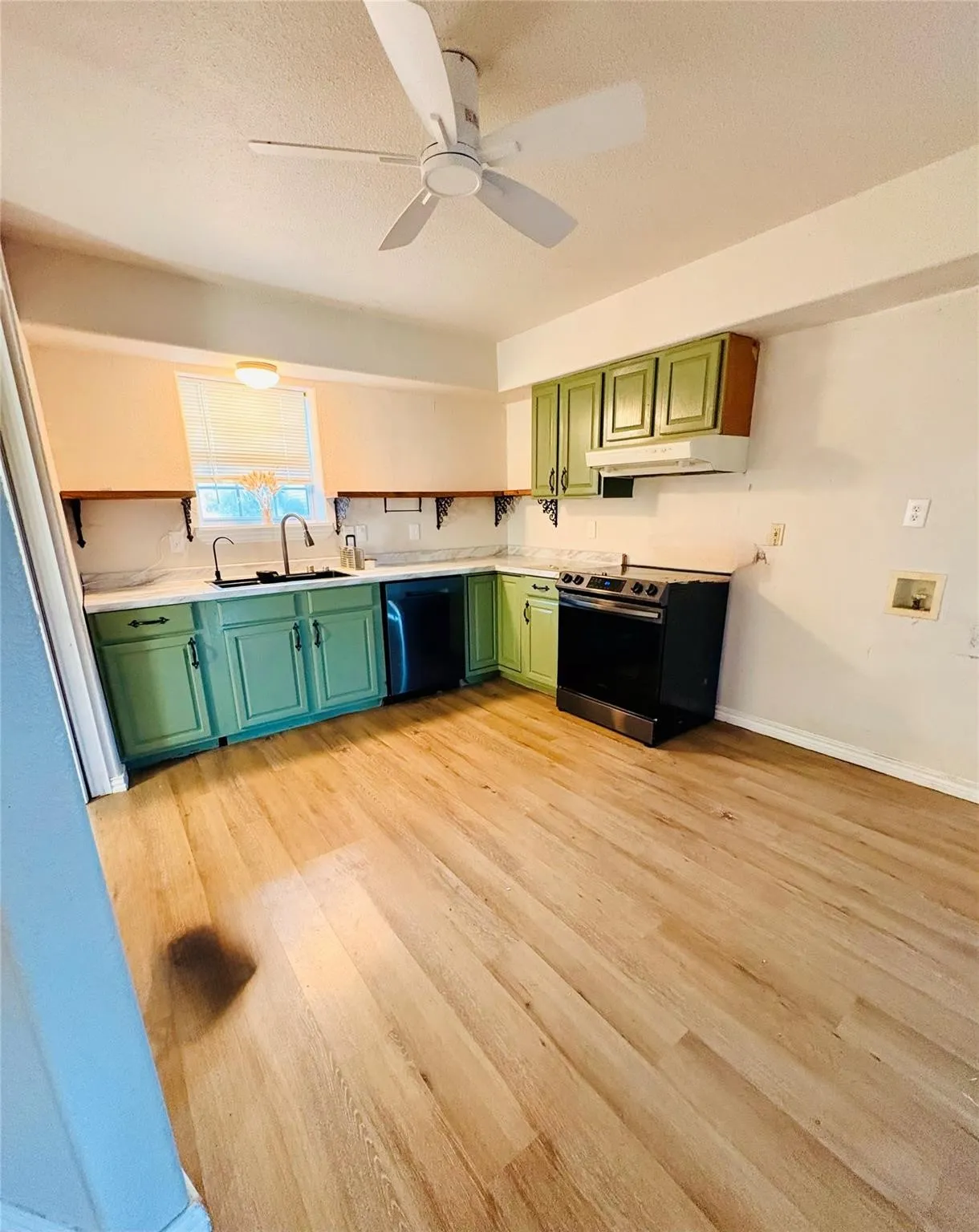 Laminate finish flooring, ceiling fan, colorful cabinetry, white countertops, and stainless steel appliances