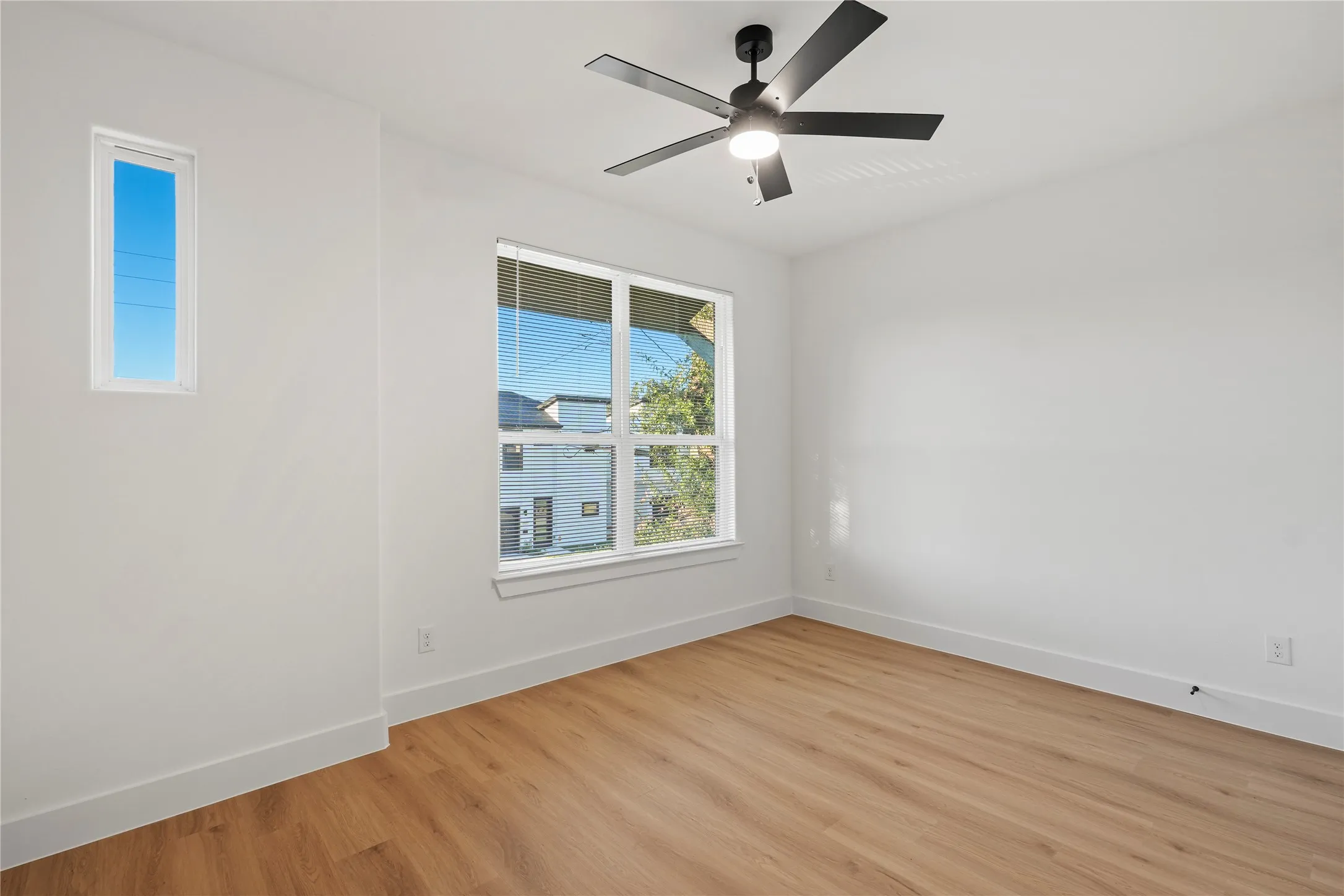 Unfurnished room with ceiling fan and light hardwood / wood-style floors