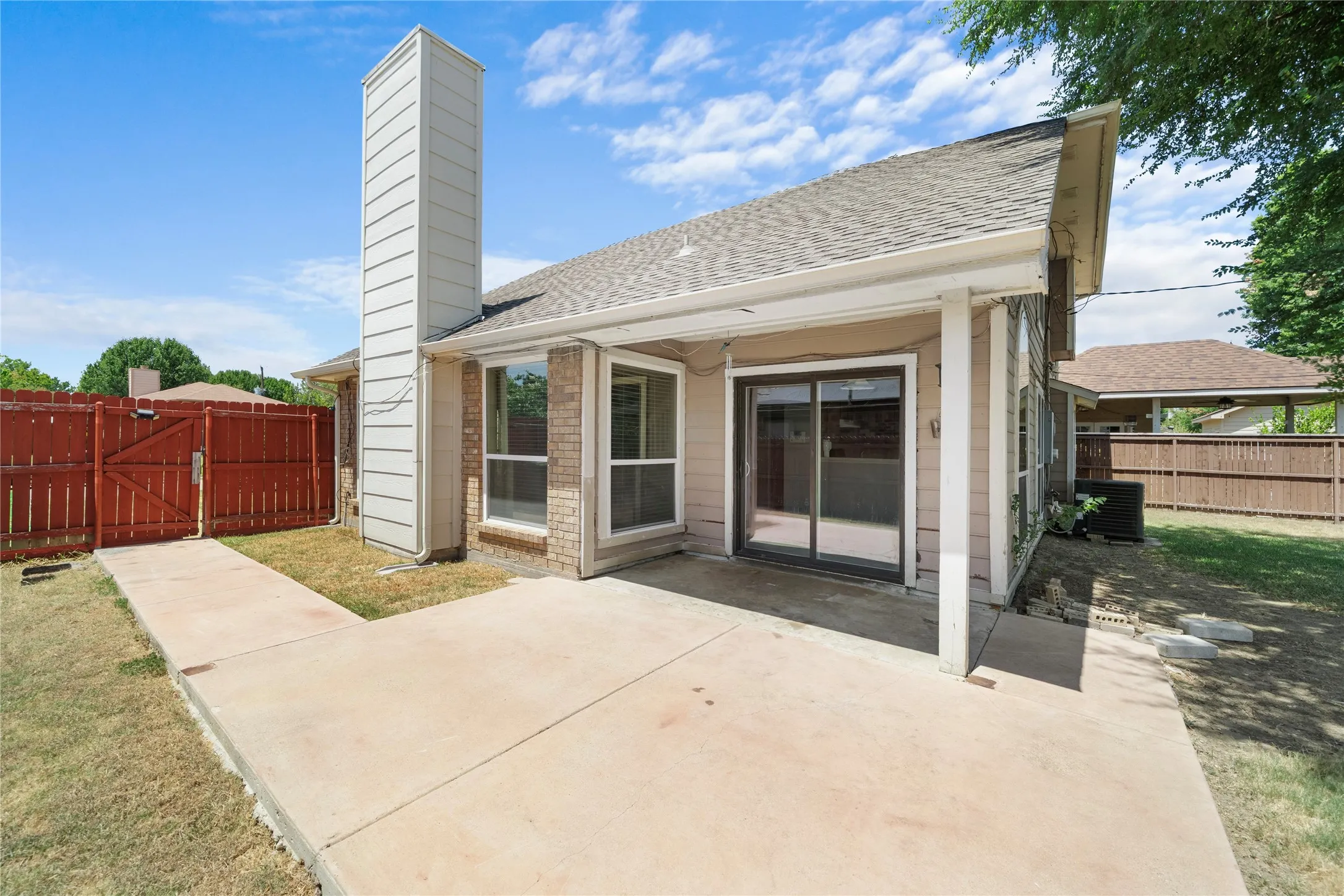 Spacious concrete patio with sliding glass door access