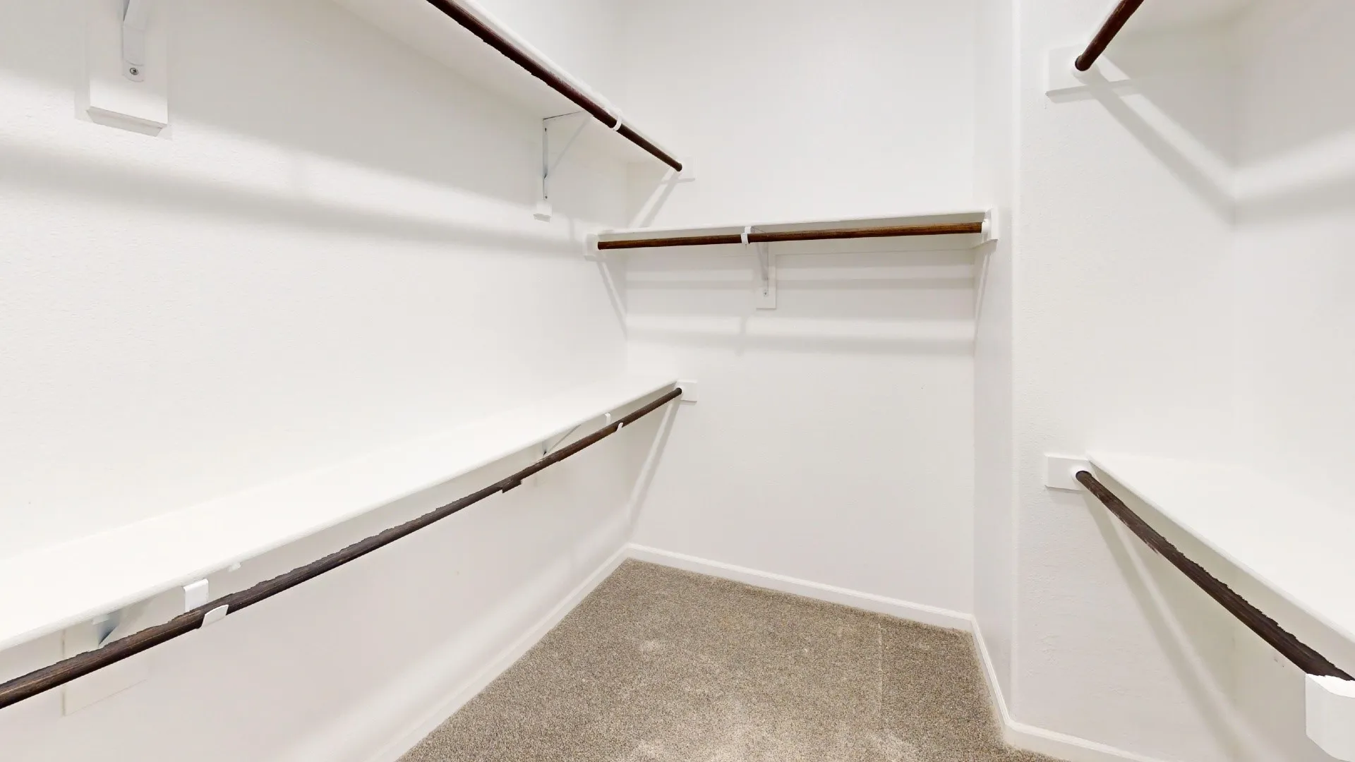 White walls with multiple built-in shelving units and hanging rods