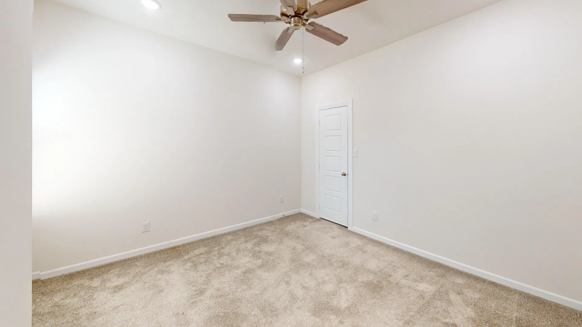 Neutral-toned carpeting, recessed ceiling lighting, and a ceiling fan with wood-finish blades