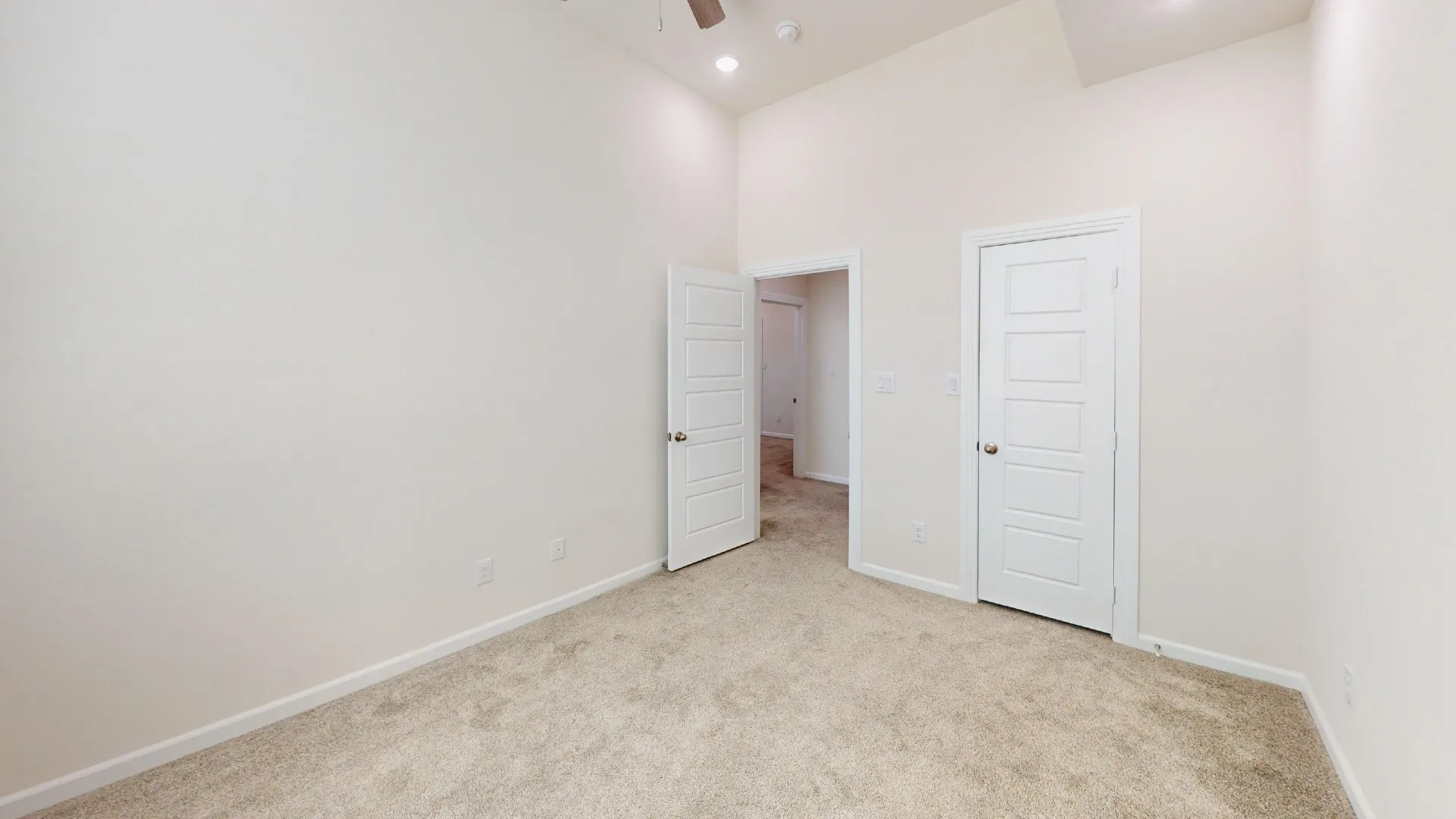 Carpeted flooring, vaulted ceiling, recessed lighting, and white paneled doors
