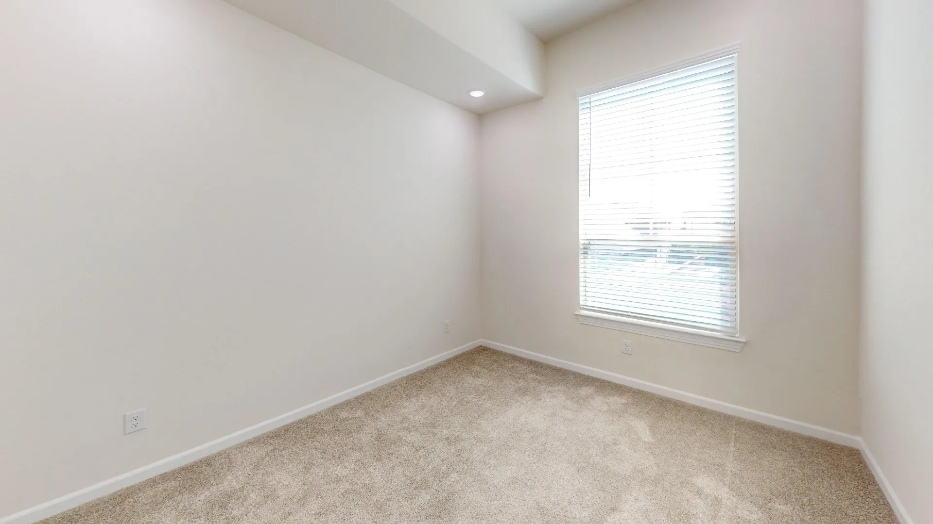Recessed lighting, neutral wall paint, window with blinds, and light-colored carpeting