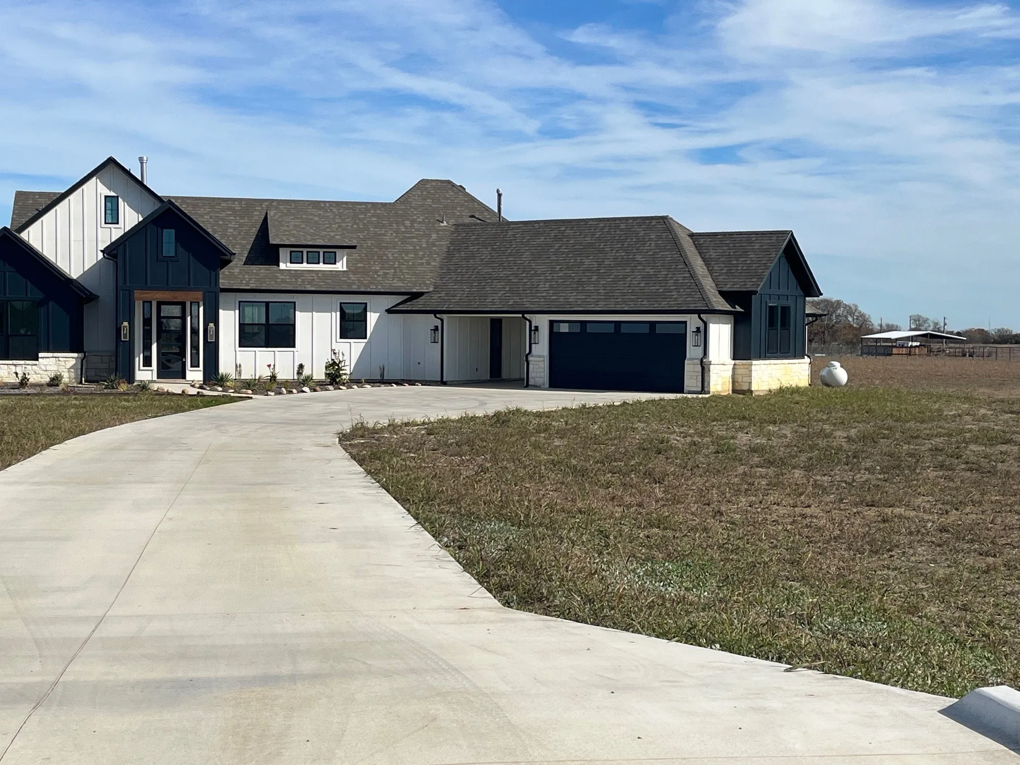 Modern inspired farmhouse with a garage and a front lawn