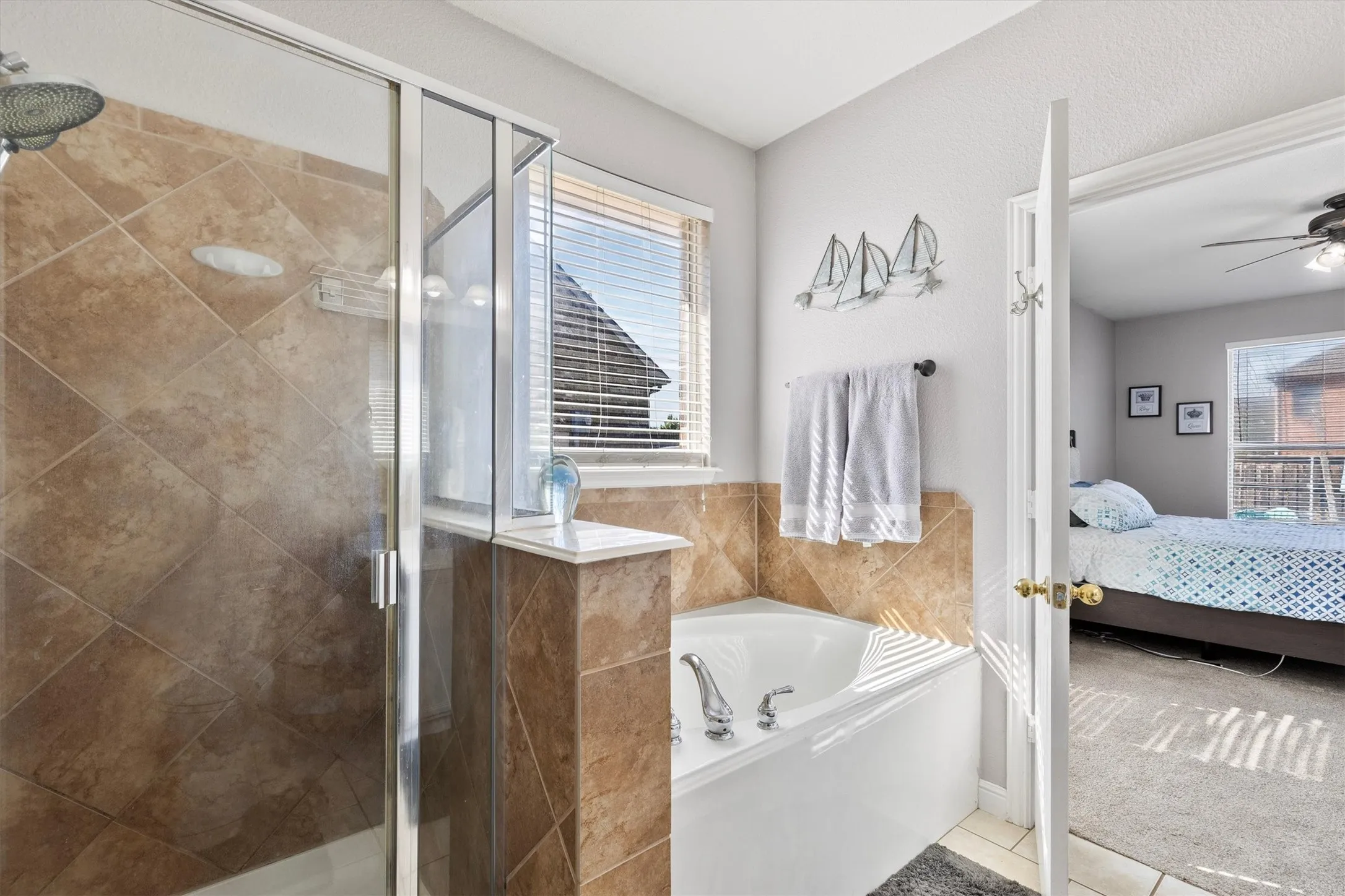 Walk-in shower with glass enclosure, separate bathtub, and tile surround