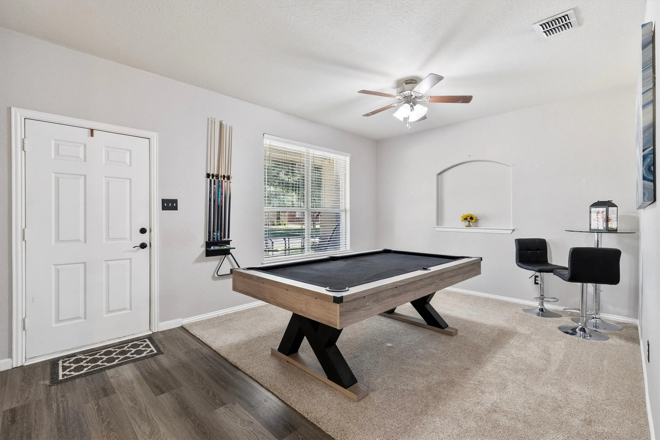Vaulted ceiling featuring a ceiling fan, recessed wall niche, and natural light from a window with blinds