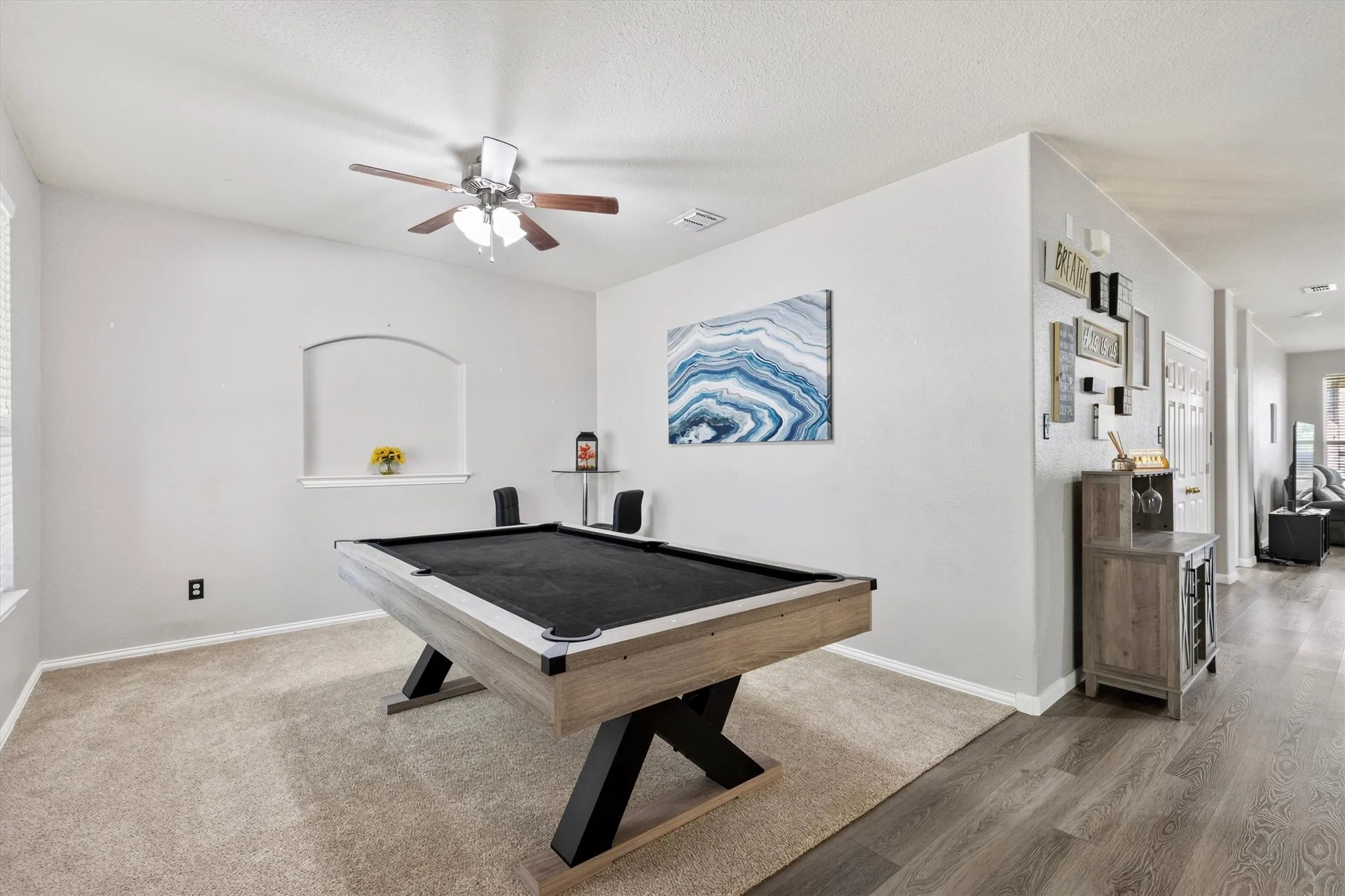 Vaulted ceiling with a ceiling fan, arched wall niche, and wood-finish flooring