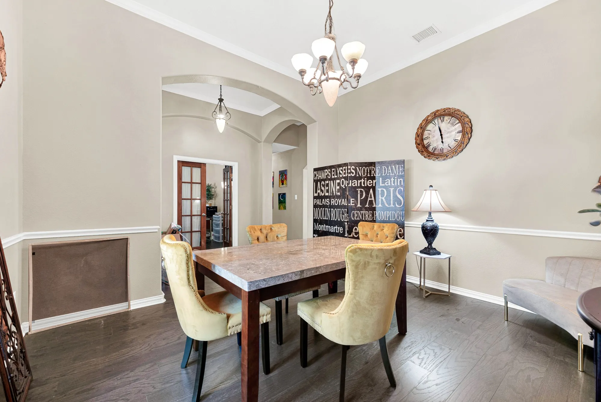 Dark wood-finish flooring with crown molding and arched doorways