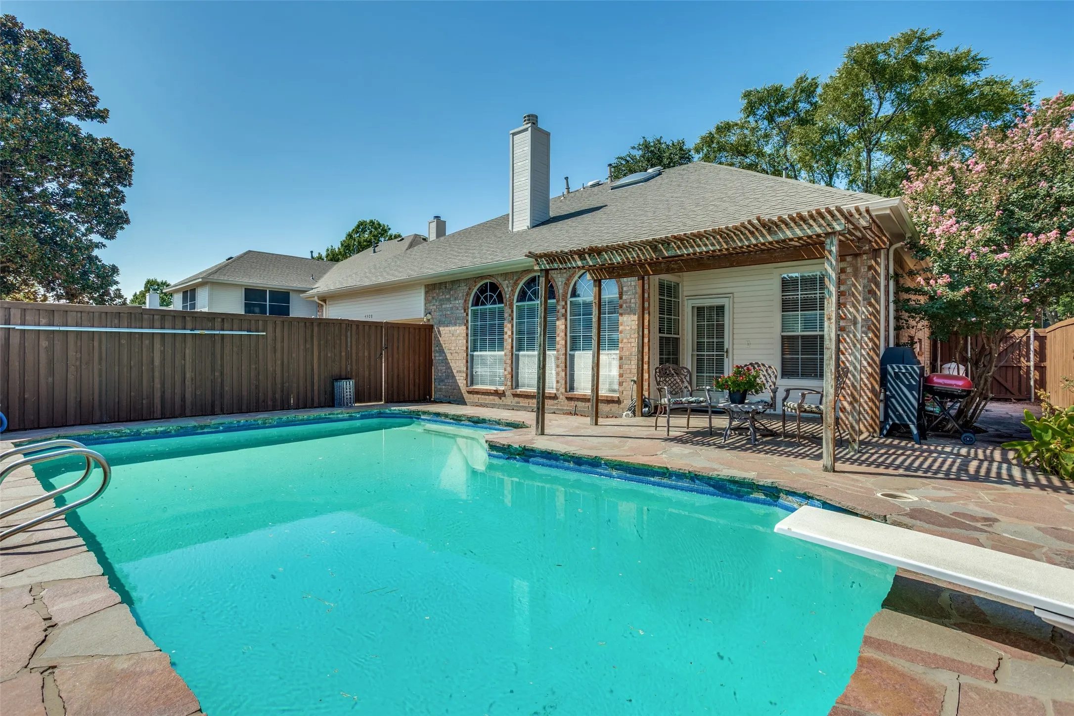 pool and covered patio with side space used for gardening supplies.