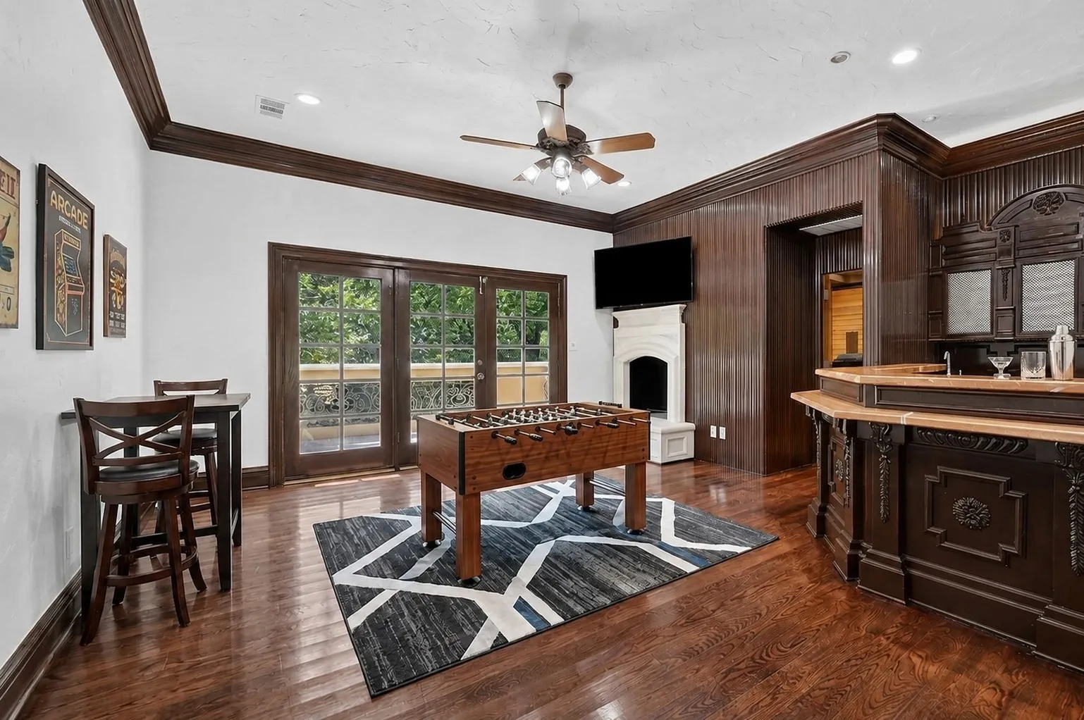 Upstairs hosts a game room with wet bar leading to a private balcony. This photo has been virtually staged
