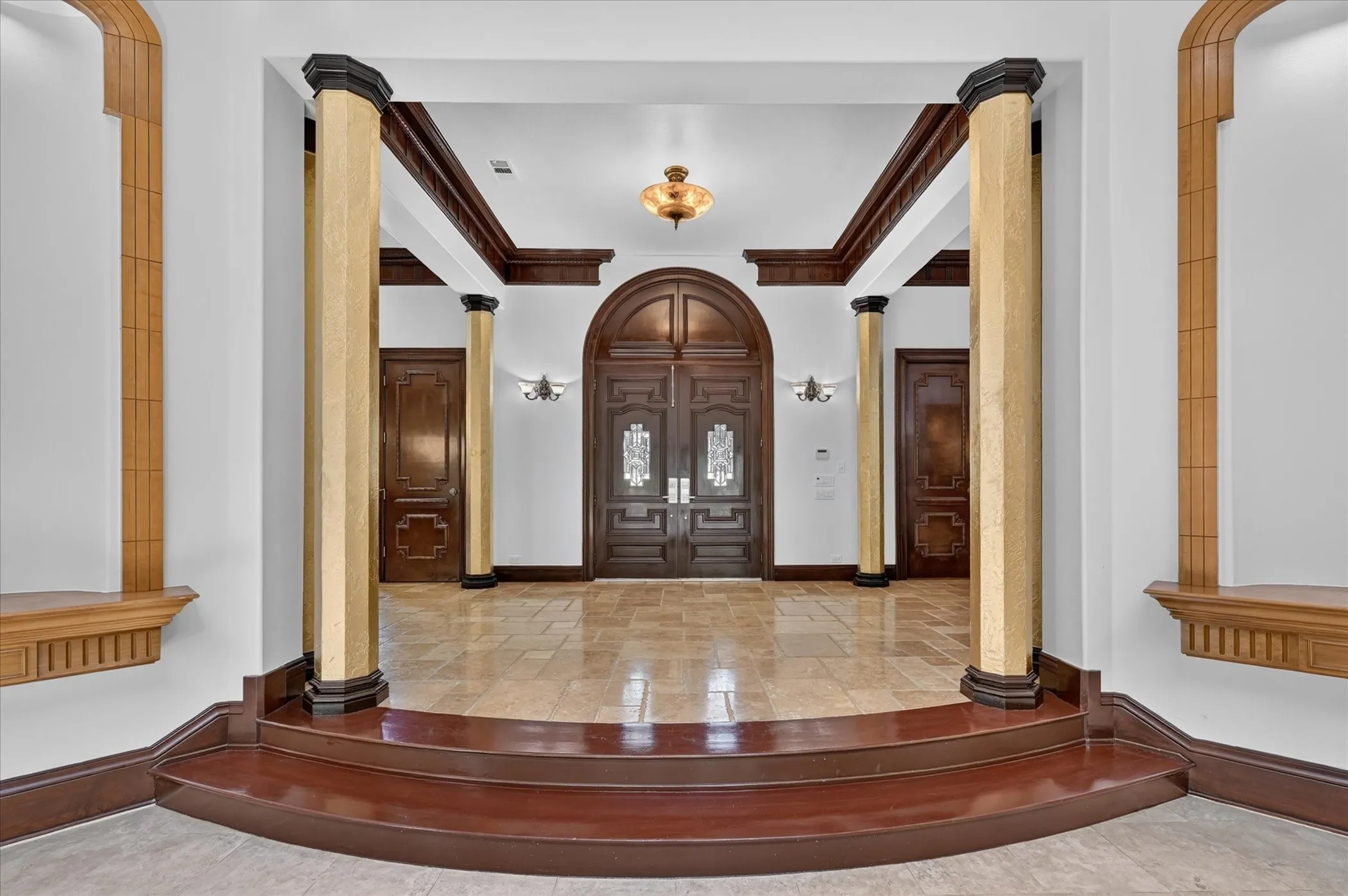 Arrive via the sweeping circle driveway to a grand entrance defined by soaring ceilings, a striking spiral staircase, and rich travertine alongside hand-scraped wood flooring.