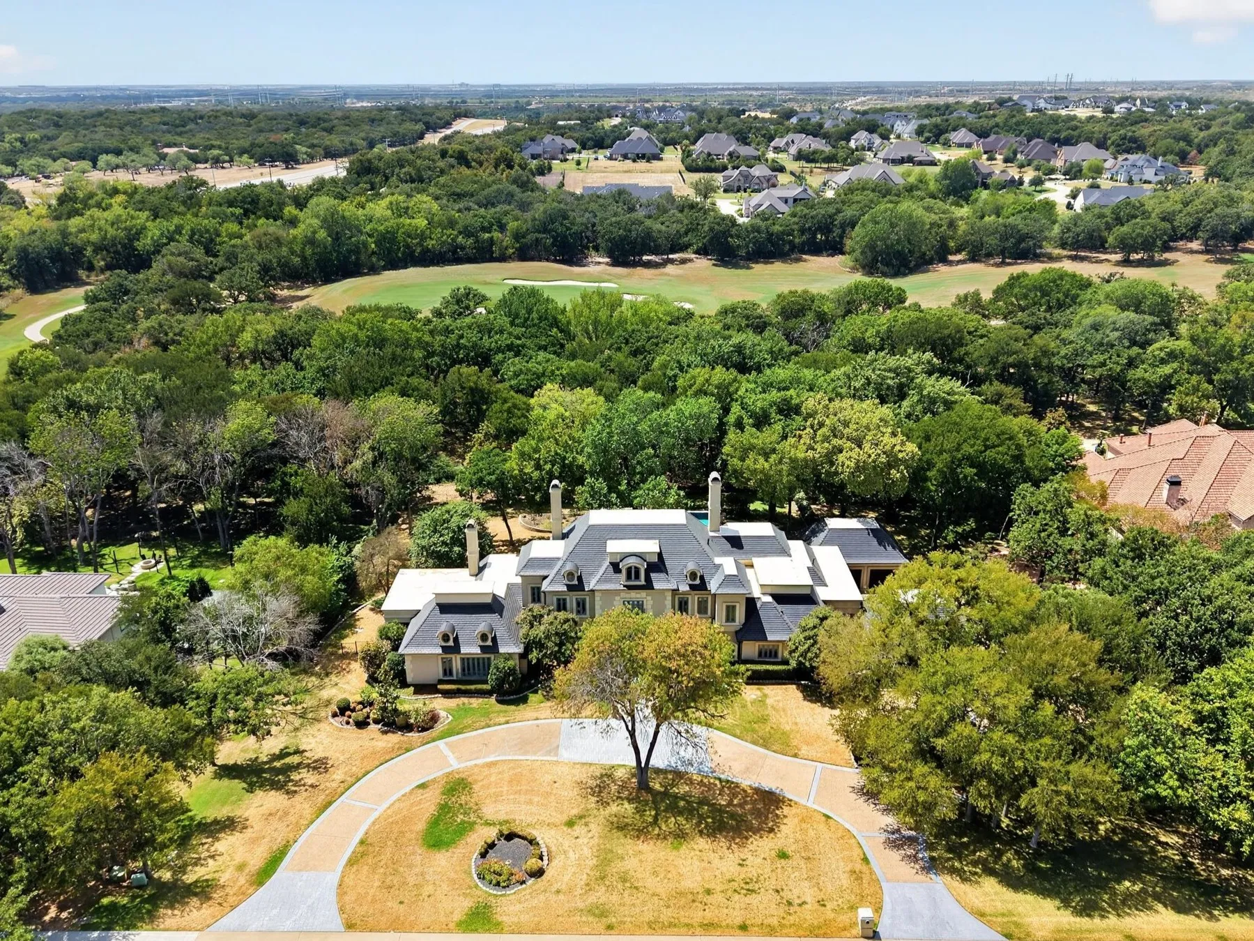 This modern French château-inspired custom estate sits on 2 acres within the exclusive gated and guarded Tour 18 community, delivering an exceptional resort-style setting within sought-after Argyle ISD.