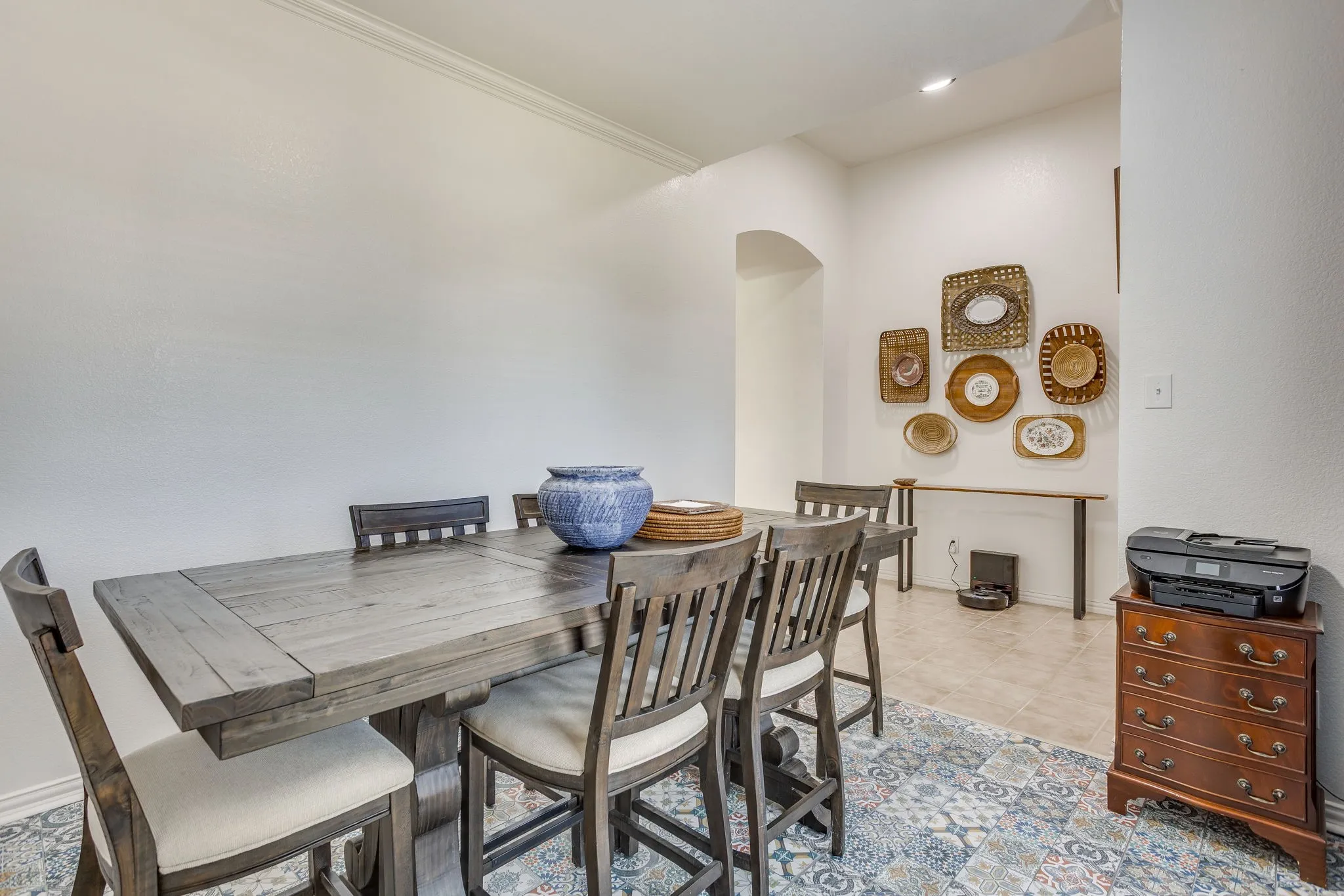 Neutral wall paint, crown molding, and an arched entry