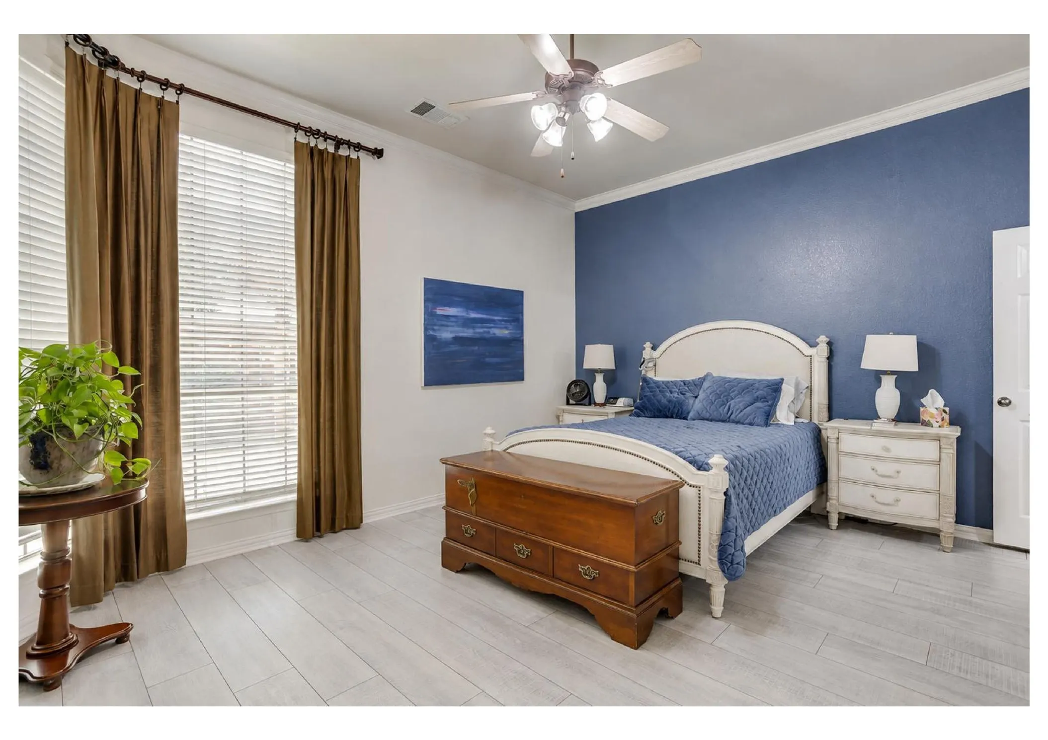 Wide window with horizontal blinds, wood-finish flooring, ceiling fan with integrated lighting, and crown molding.  edited photo with AI