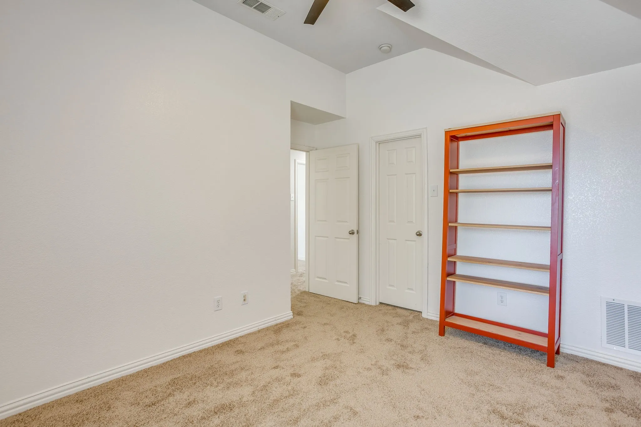 Carpeted flooring with white baseboards, a ceiling fan, and white doors
