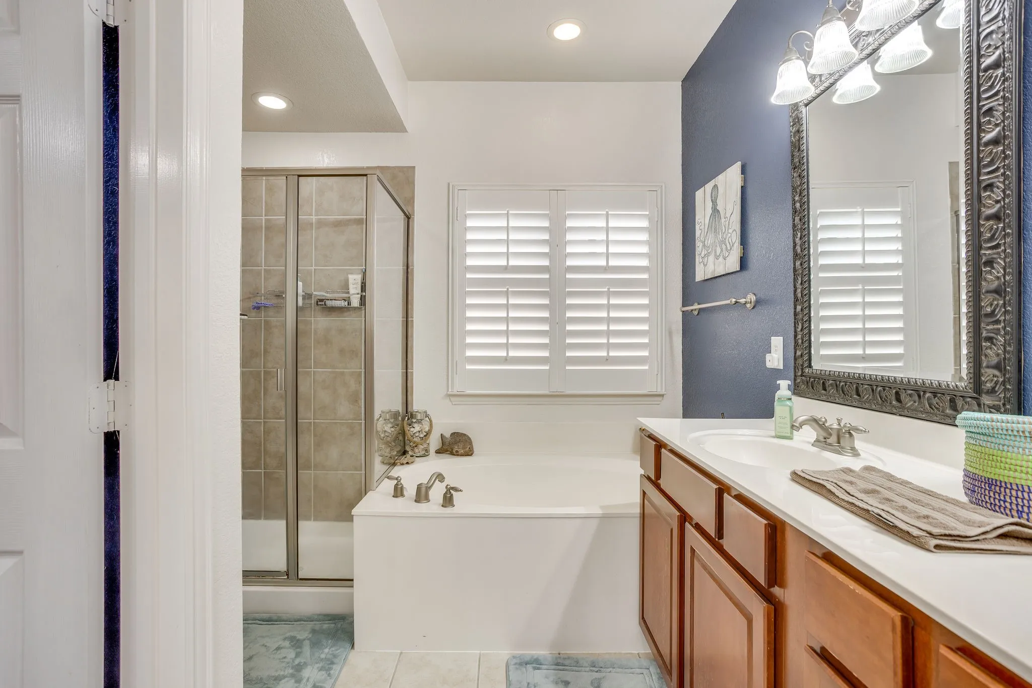 Double vanity with integrated sink, framed mirror, and wood-finish cabinetry