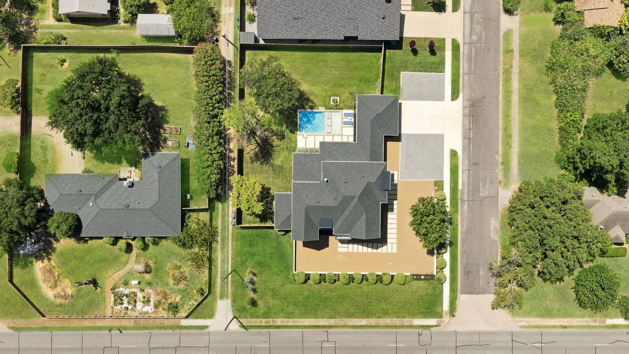 Contemporary residence featuring a private pool, extensive hardscaping, and a lush lawn