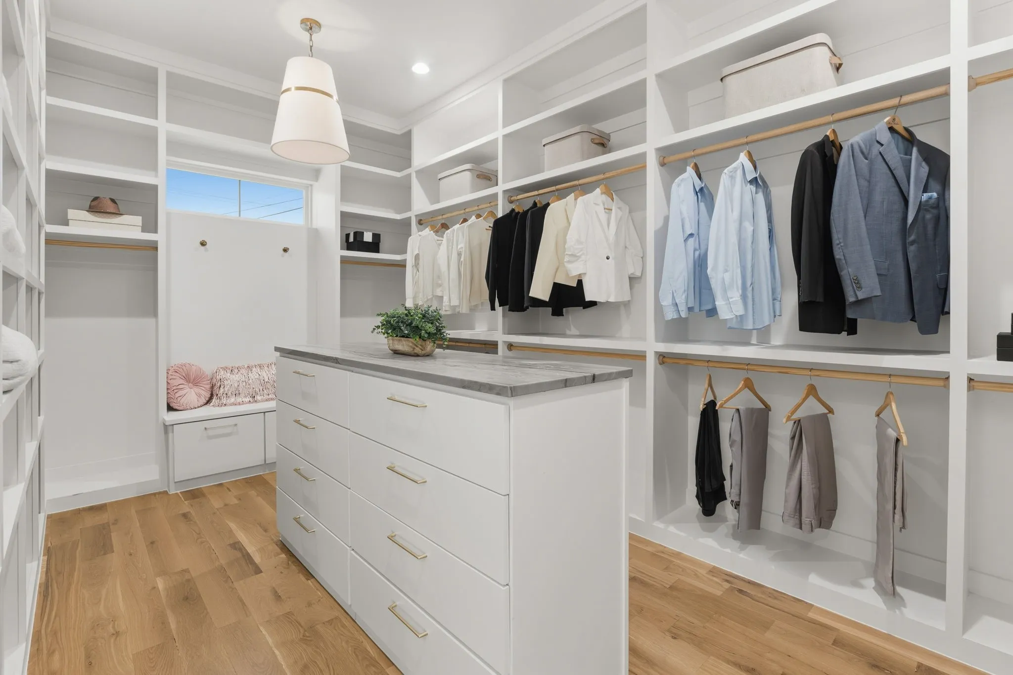 White built-in cabinetry, wood-finish flooring, central island with storage, window, and recessed lighting