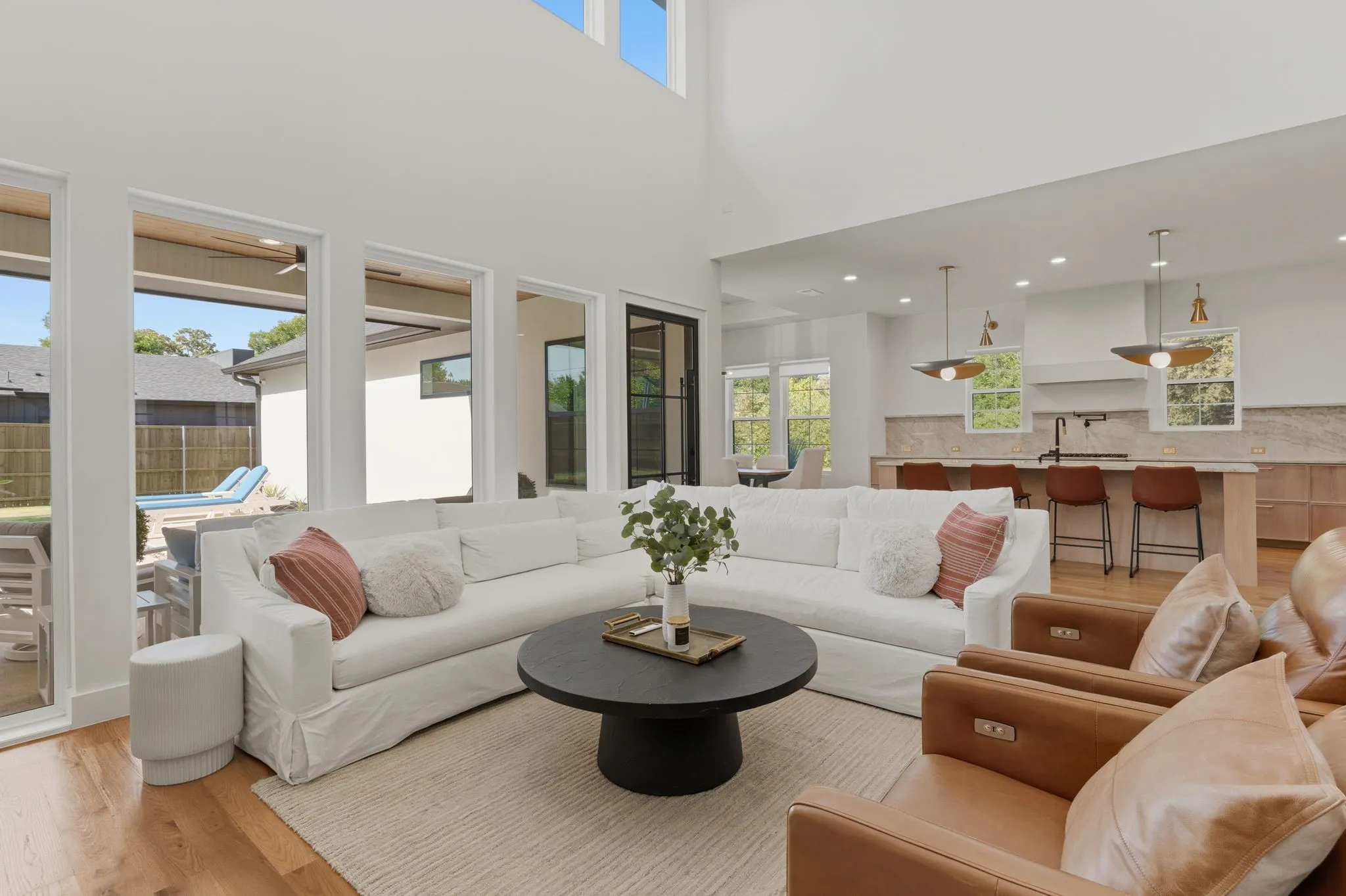 Spacious open-concept living area with soaring ceilings and wood-finish flooring