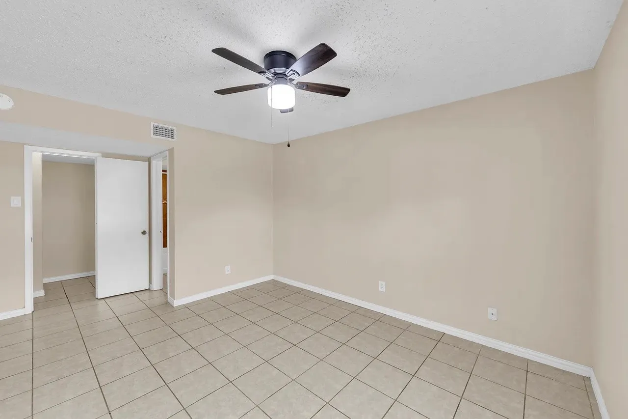 Tile flooring, neutral wall tones, ceiling fan with integrated lighting, and white trim