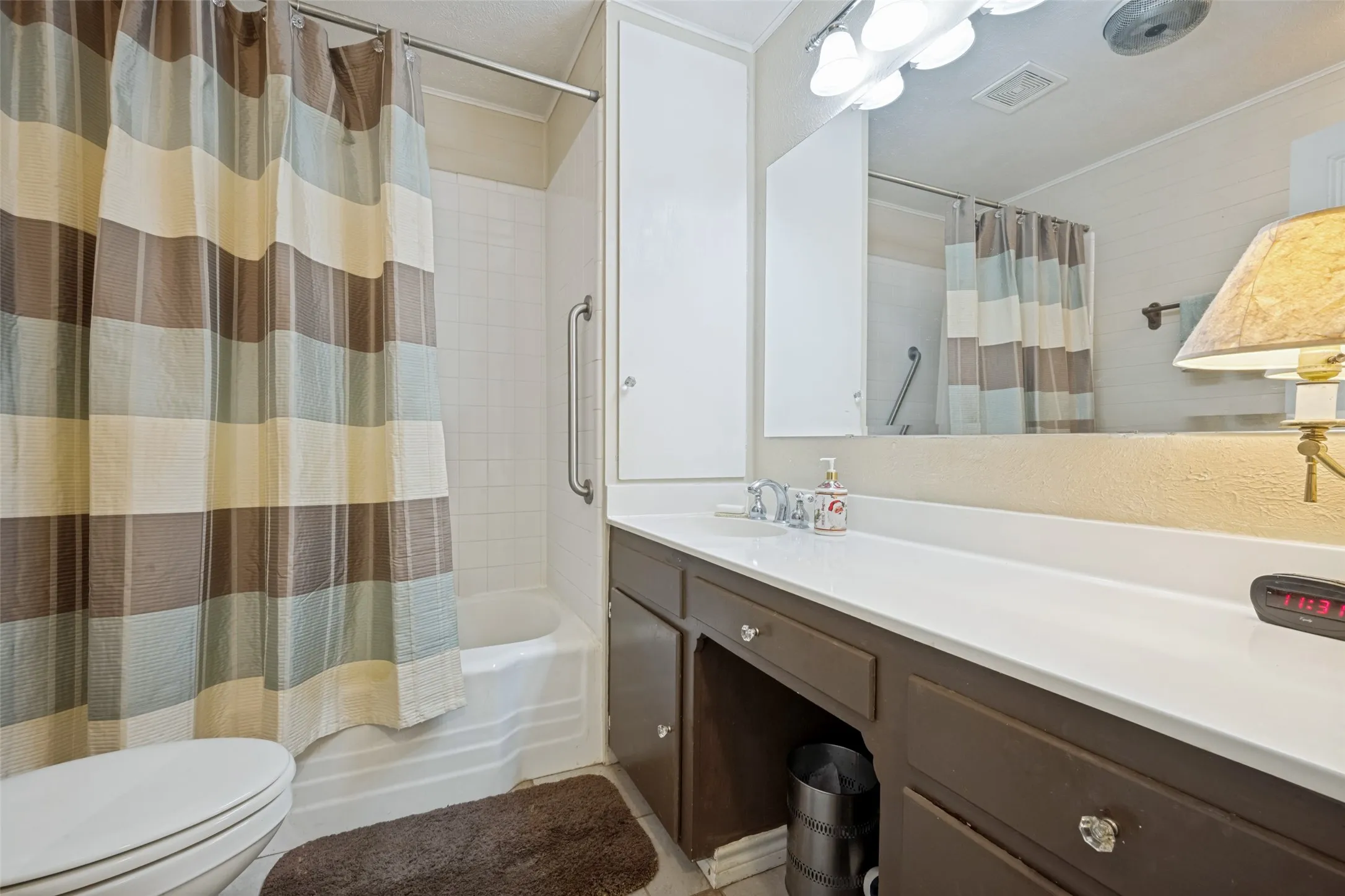 Built-in vanity with a single sink, an integrated countertop, and an overhead mirror