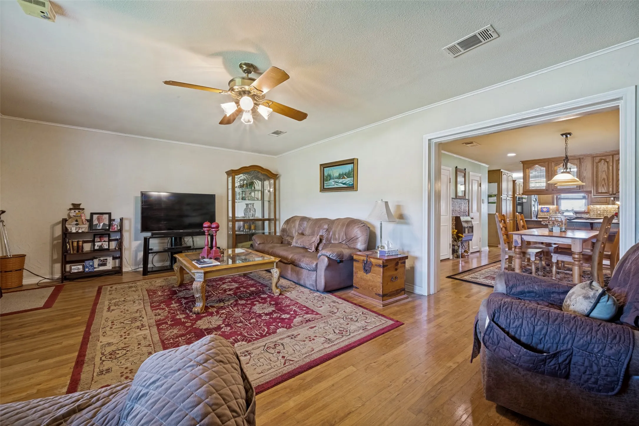 Hardwood flooring throughout, recessed lighting, and a ceiling fan with light fixture