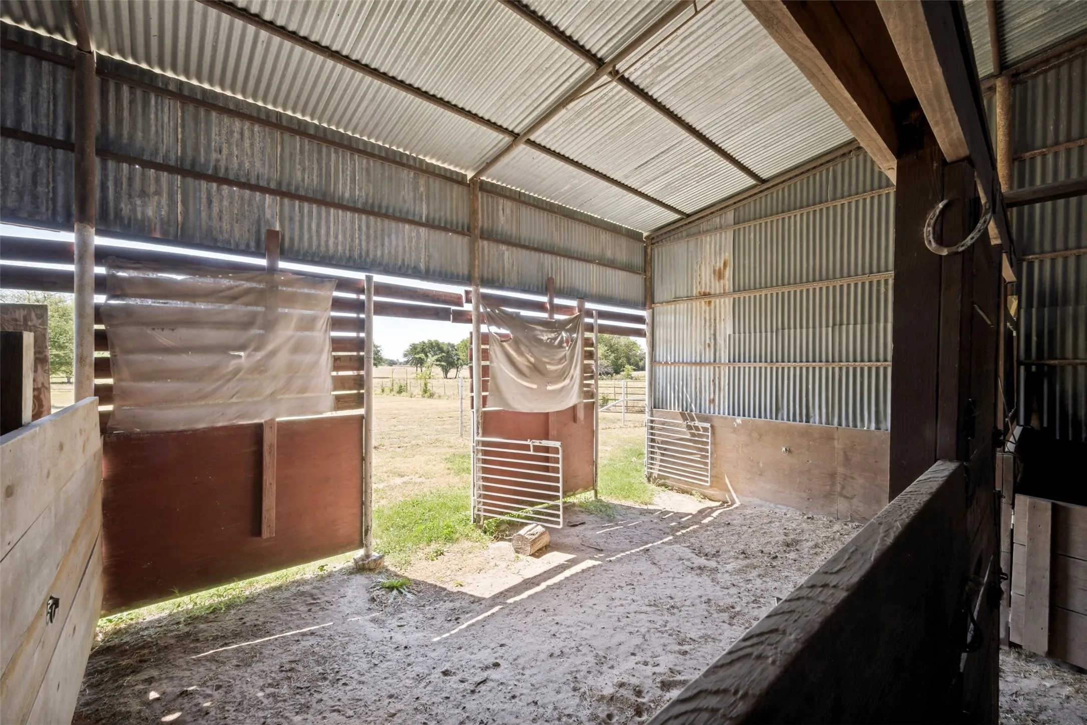 Barn structure featuring a corrugated metal roof, wood support beams, and metal siding