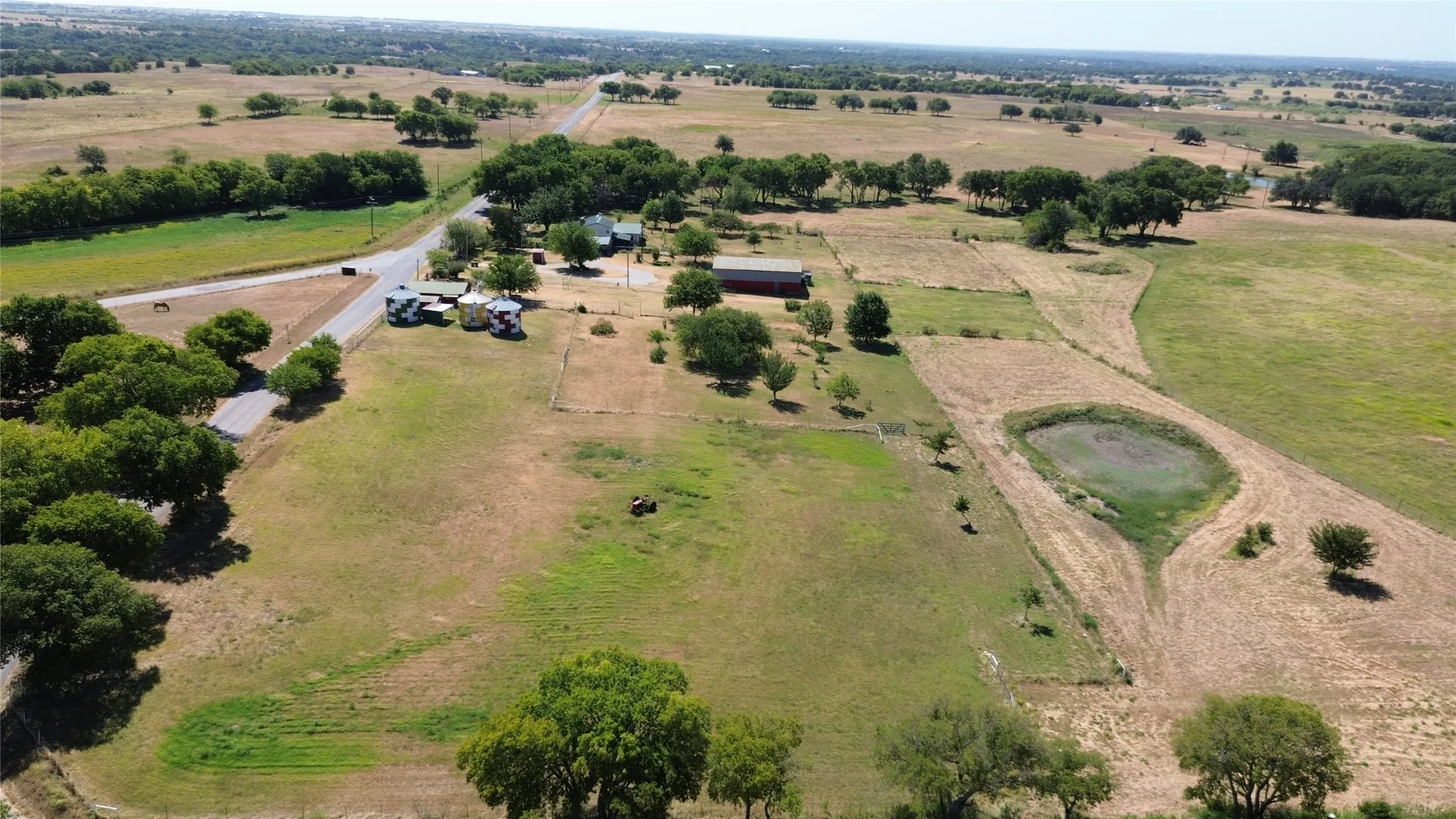 Expansive acreage featuring a pond, mature trees, and a road frontage