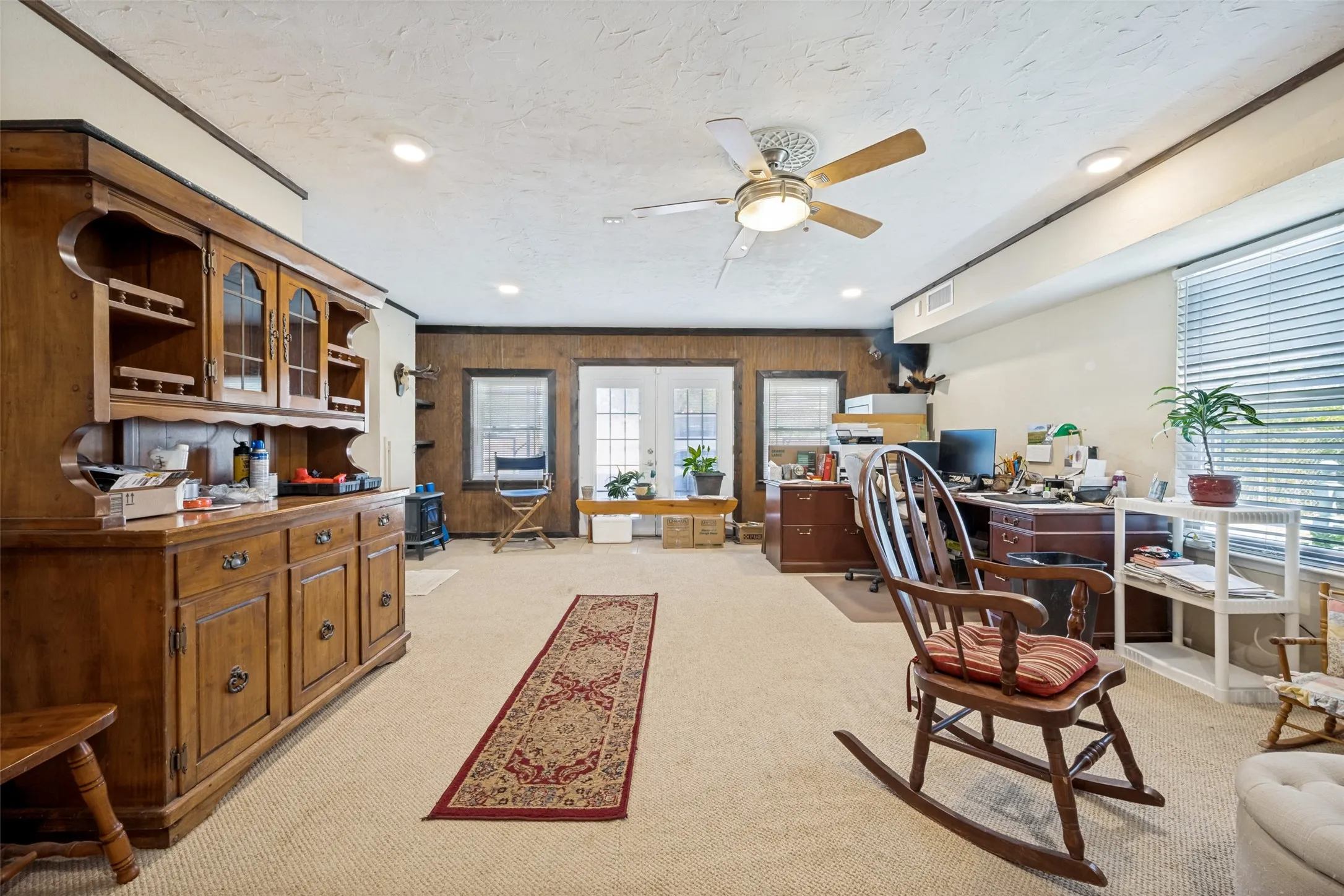Recessed lighting, ceiling fan, carpeted flooring, and wood-paneled walls