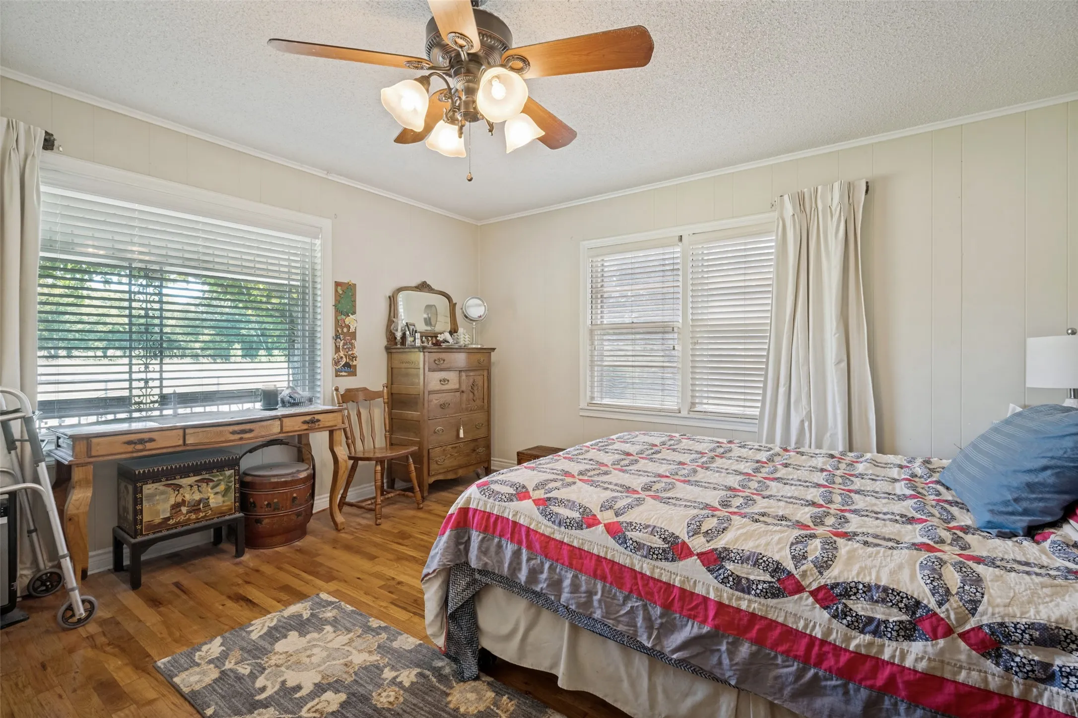 Wood-finish flooring with multiple windows and a ceiling fan