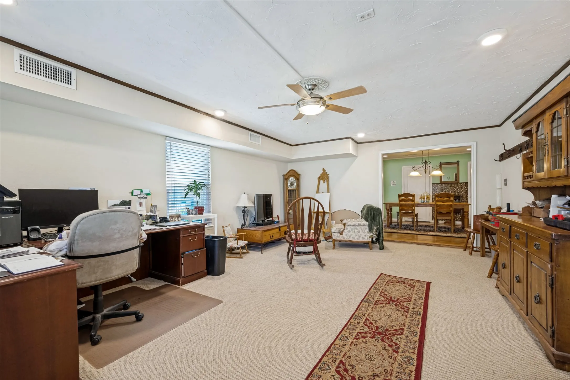 Recessed lighting, wood-finish trim, ceiling fan, carpet flooring, and a defined archway opening