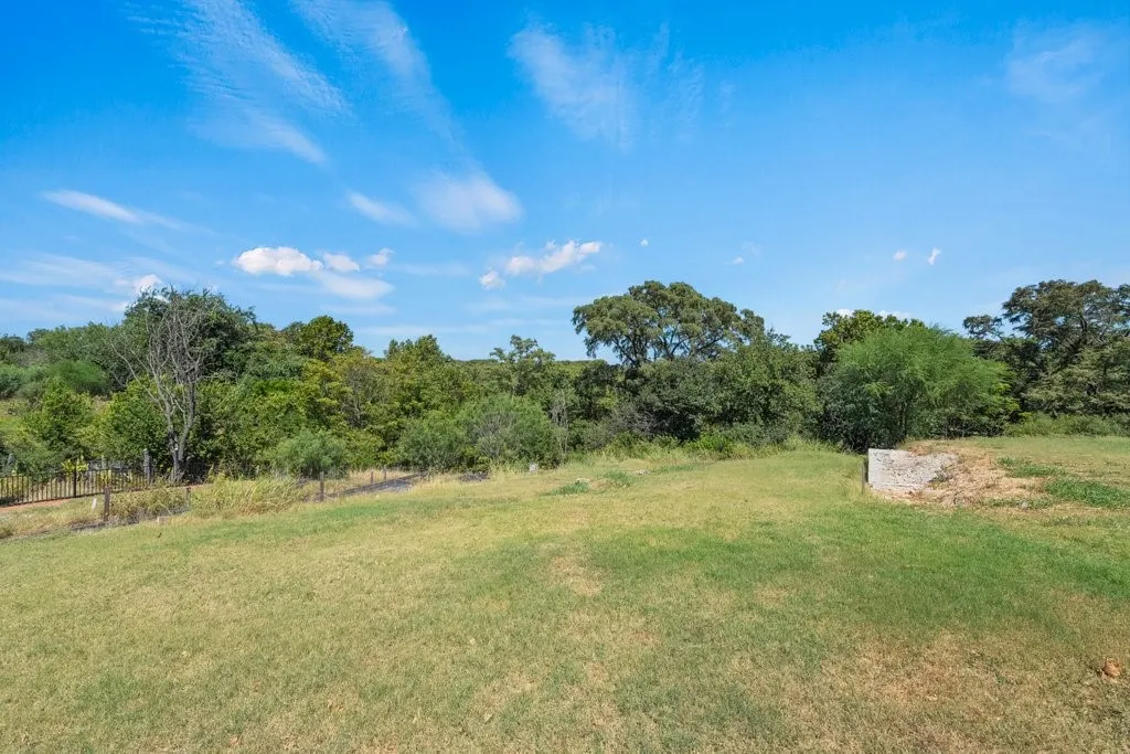 Expansive green space featuring natural landscaping and a distinct rectangular concrete pad