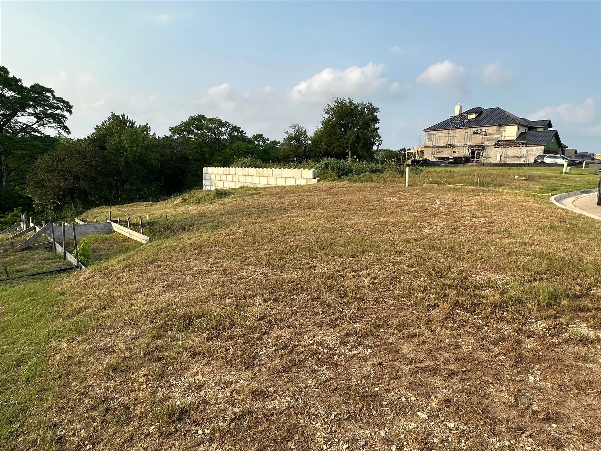 Sloping terrain with partially constructed retaining walls and a concrete block wall