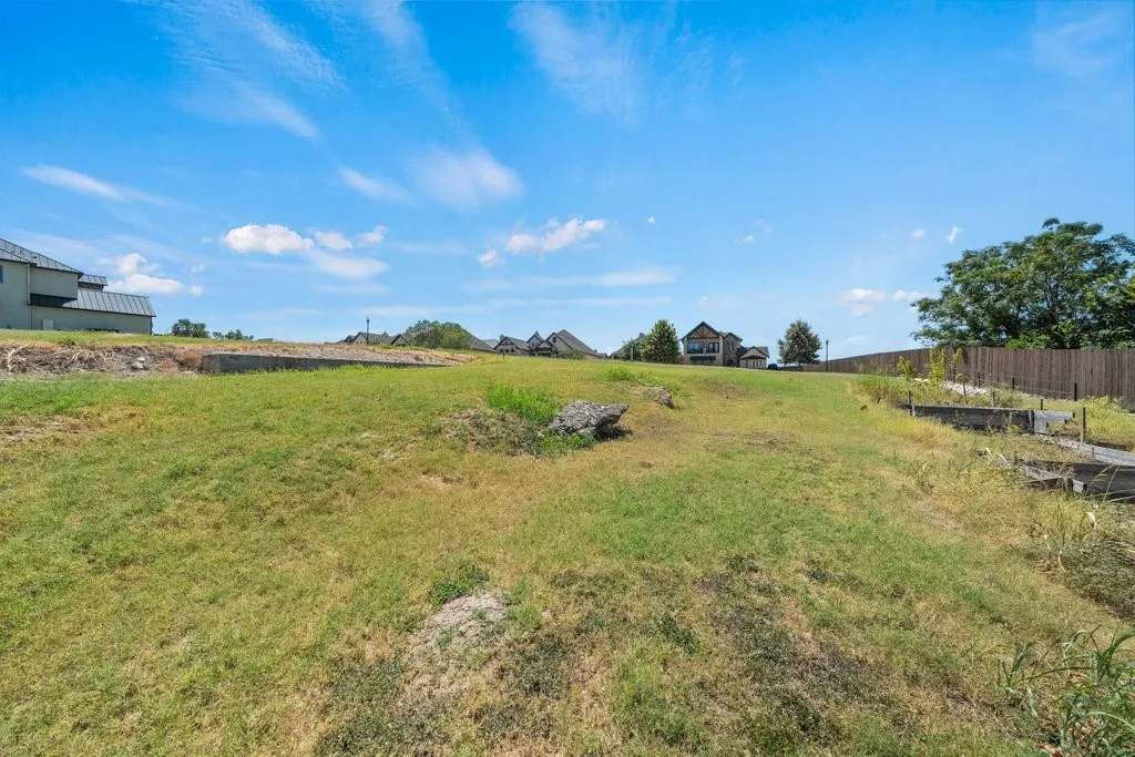 Expansive lot featuring a sloped terrain and partial fencing